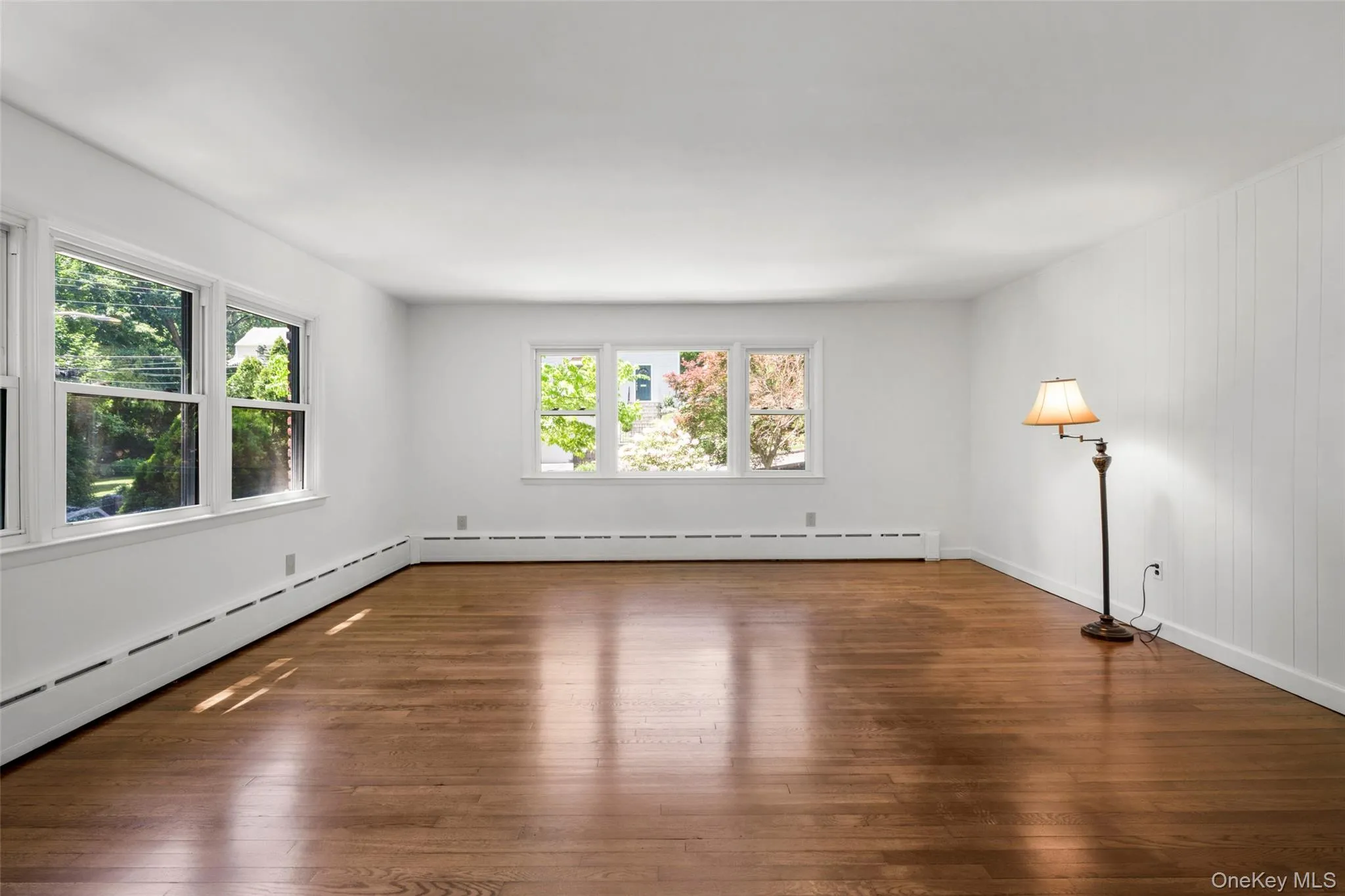 Hardwood flooring complements white walls and multiple windows Hardwood flooring complements white walls and multiple windows