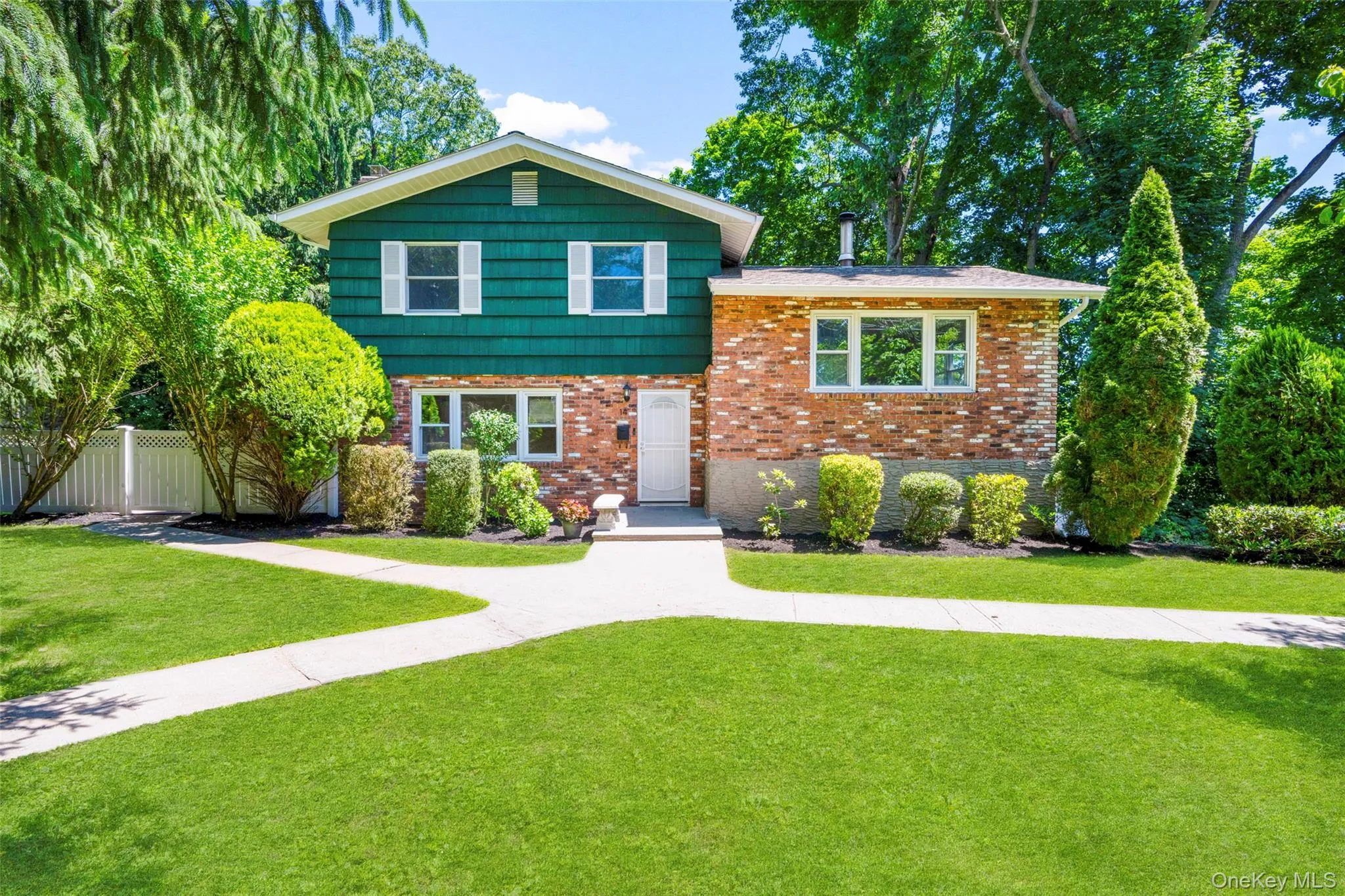 Two-story residence featuring a combination of brick and shingle siding with white window trim Two-story residence featuring a combination of brick and shingle siding with white window trim