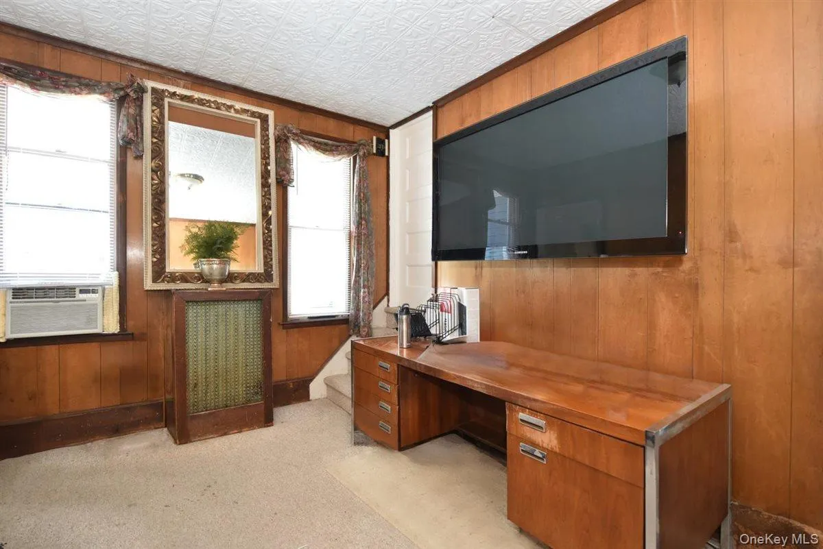 Office area featuring wooden walls and an ornate ceiling Office area featuring wooden walls and an ornate ceiling