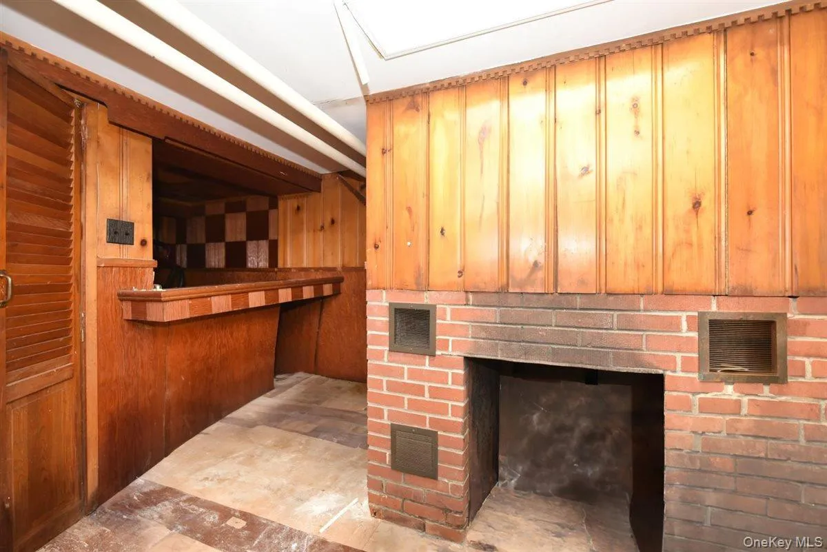 Bar featuring wooden walls and a fireplace Bar featuring wooden walls and a fireplace
