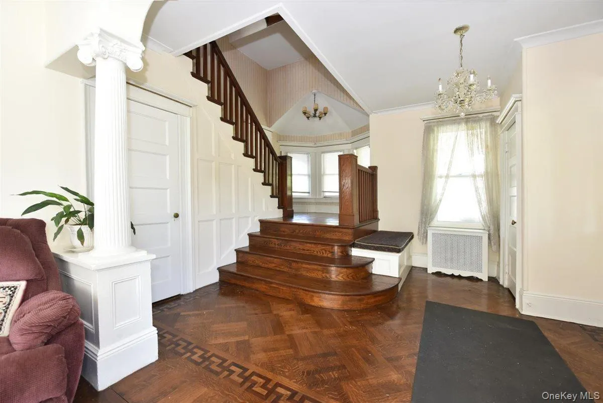 Entryway with healthy amount of natural light, radiator heating unit, a chandelier, and crown molding Entryway with healthy amount of natural light, radiator heating unit, a chandelier, and crown molding