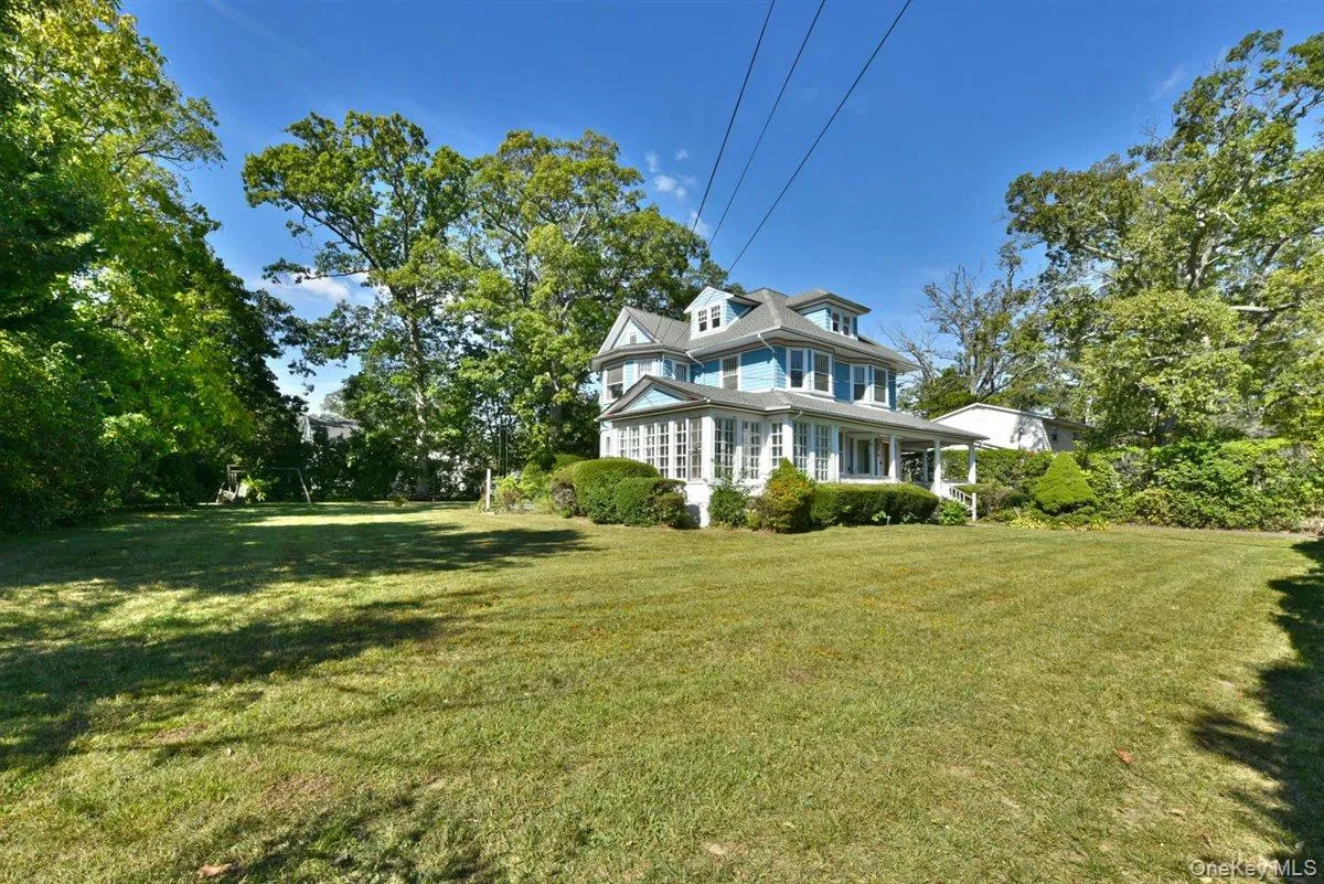 View of side of home featuring a lawn and a large porch View of side of home featuring a lawn and a large porch