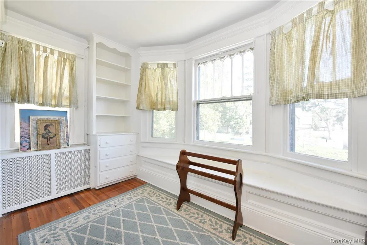 Sitting room with radiator, wood finished floors, and healthy amount of natural light Sitting room with radiator, wood finished floors, and healthy amount of natural light
