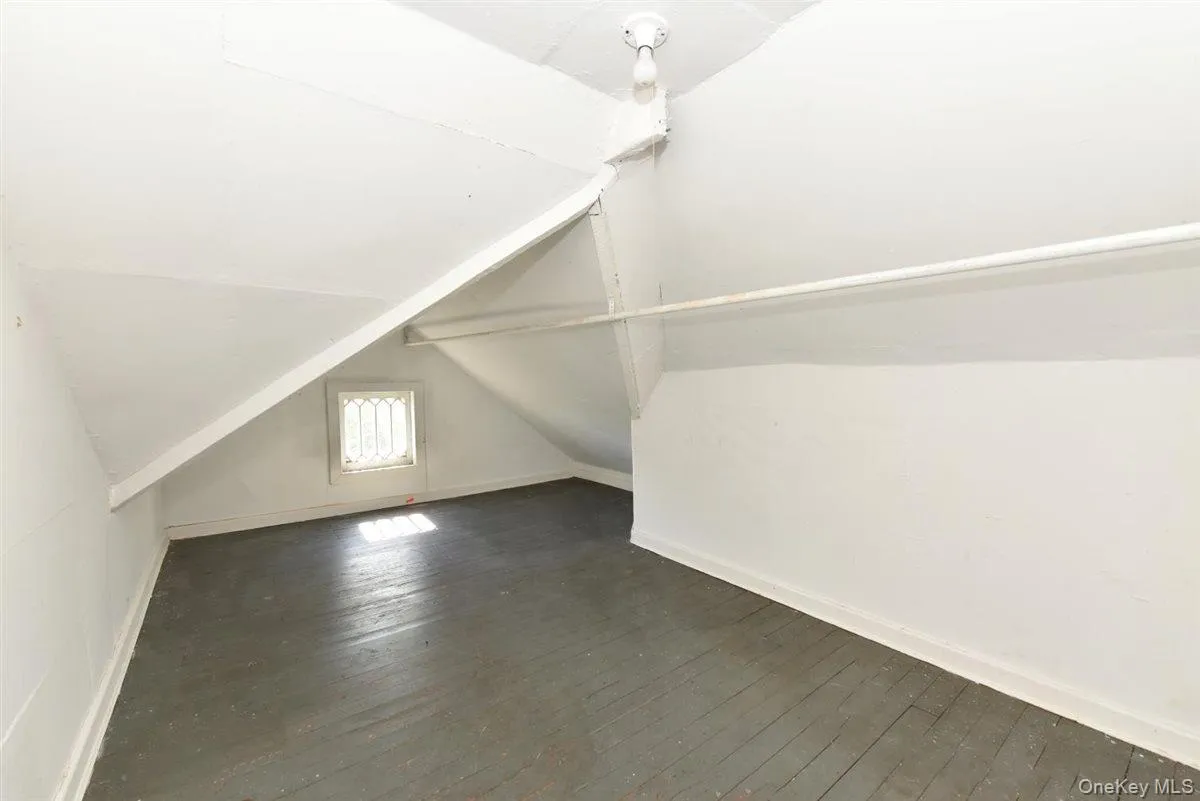 Additional living space with dark wood-style flooring and vaulted ceiling Additional living space with dark wood-style flooring and vaulted ceiling