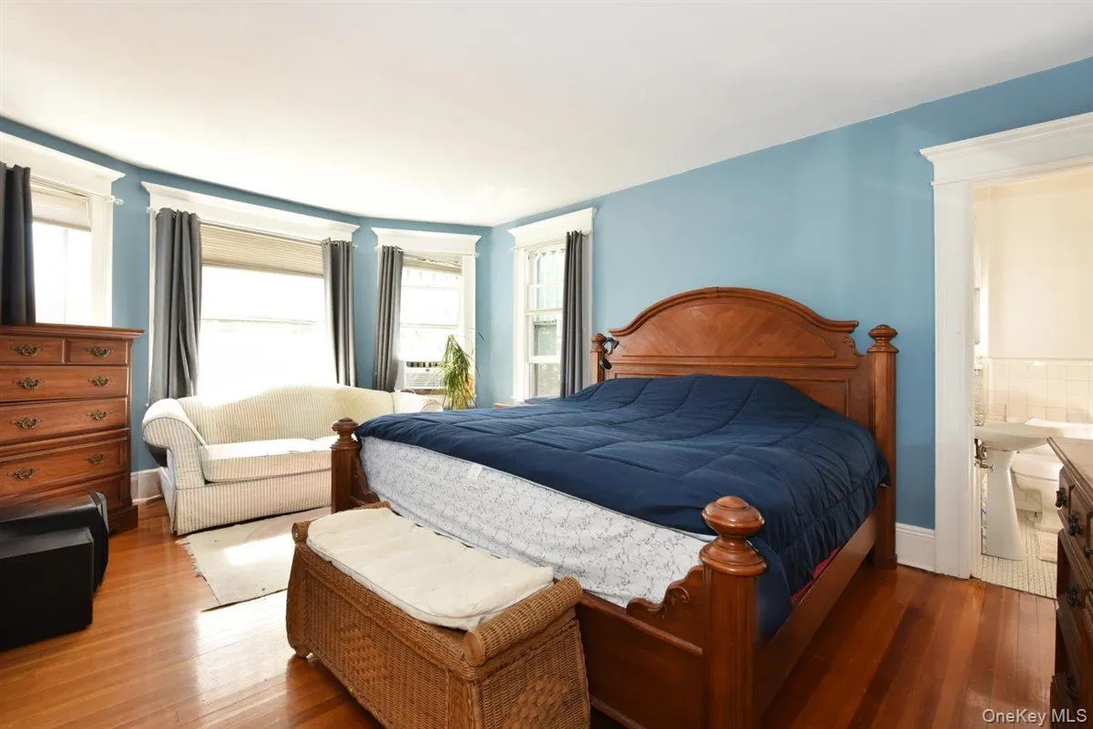 Bedroom with multiple windows and wood finished floors Bedroom with multiple windows and wood finished floors