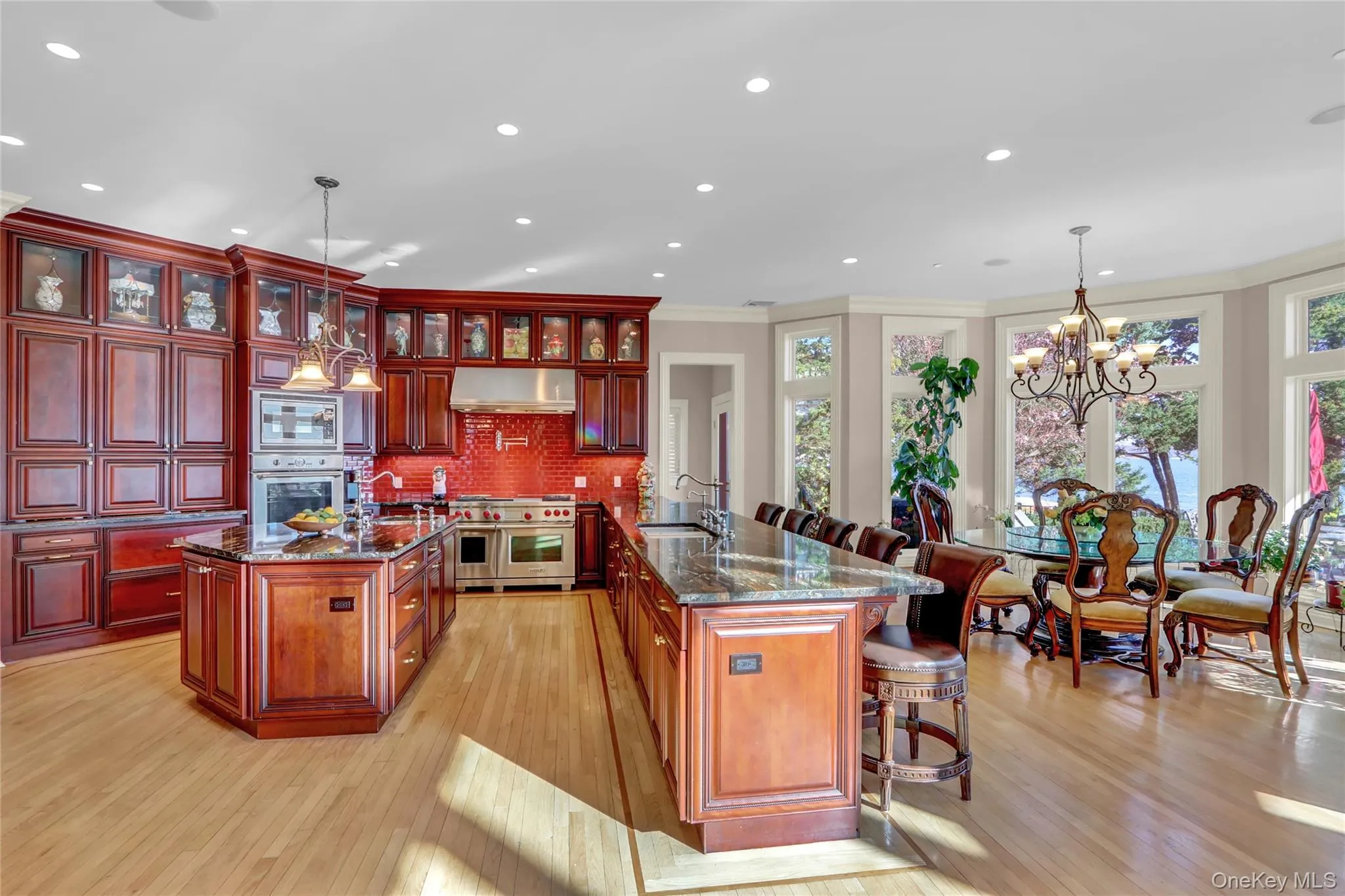 Kitchen with a kitchen island with sink, a sink, stainless steel appliances, and under cabinet range hood Kitchen with a kitchen island with sink, a sink, stainless steel appliances, and under cabinet range hood
