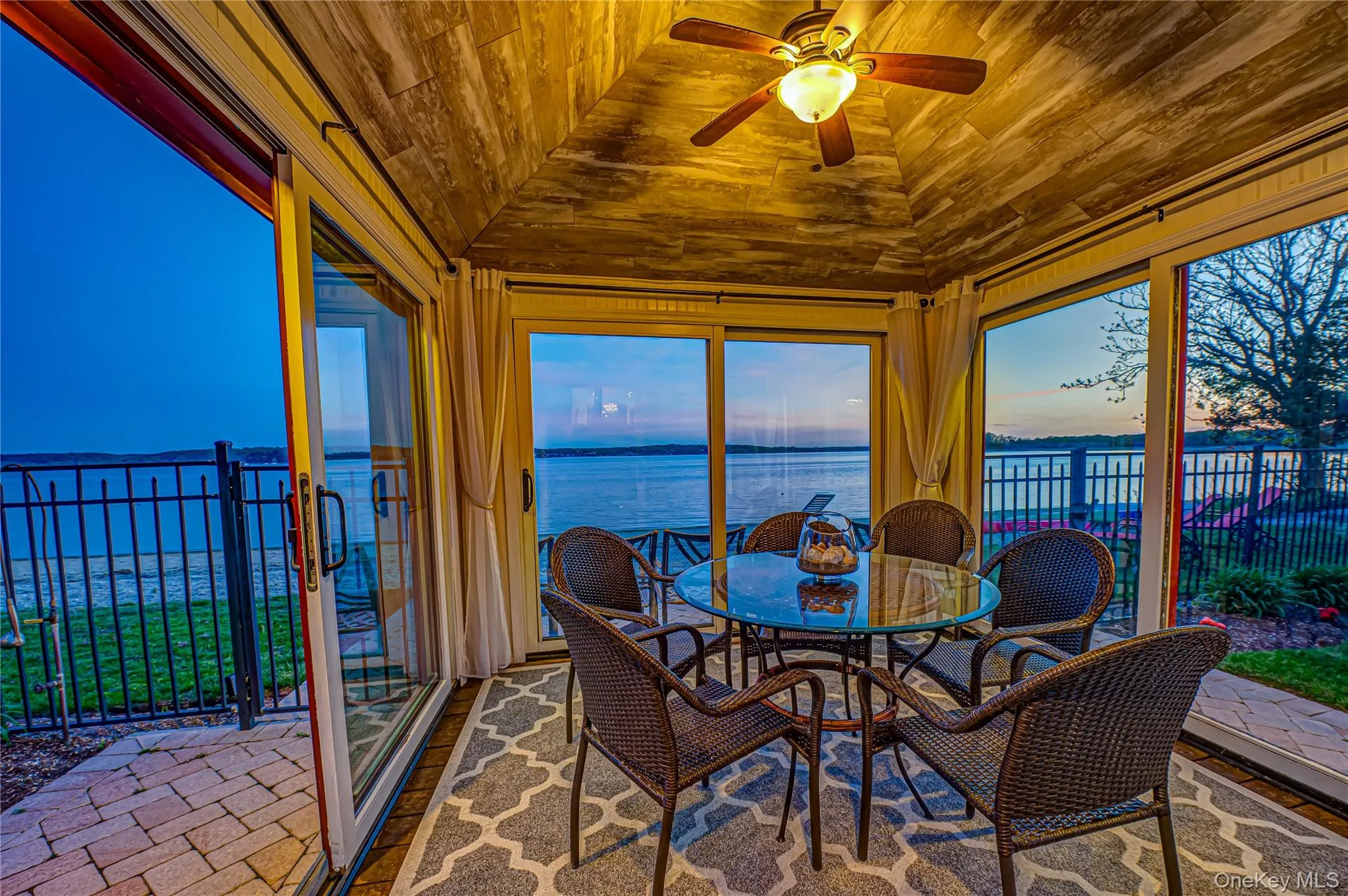 Sunroom / solarium with a water view, lofted ceiling, and wooden ceiling Sunroom / solarium with a water view, lofted ceiling, and wooden ceiling