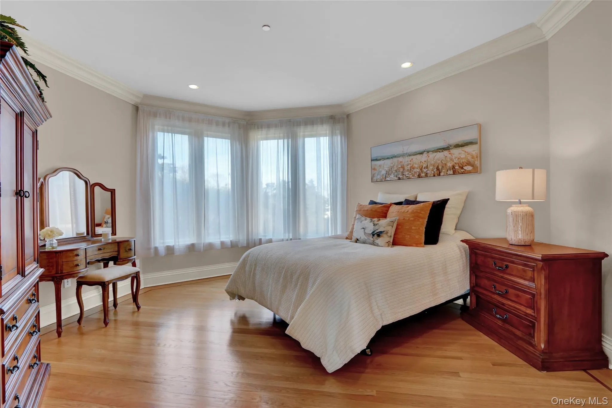 Bedroom with crown molding, light wood finished floors, and baseboards Bedroom with crown molding, light wood finished floors, and baseboards