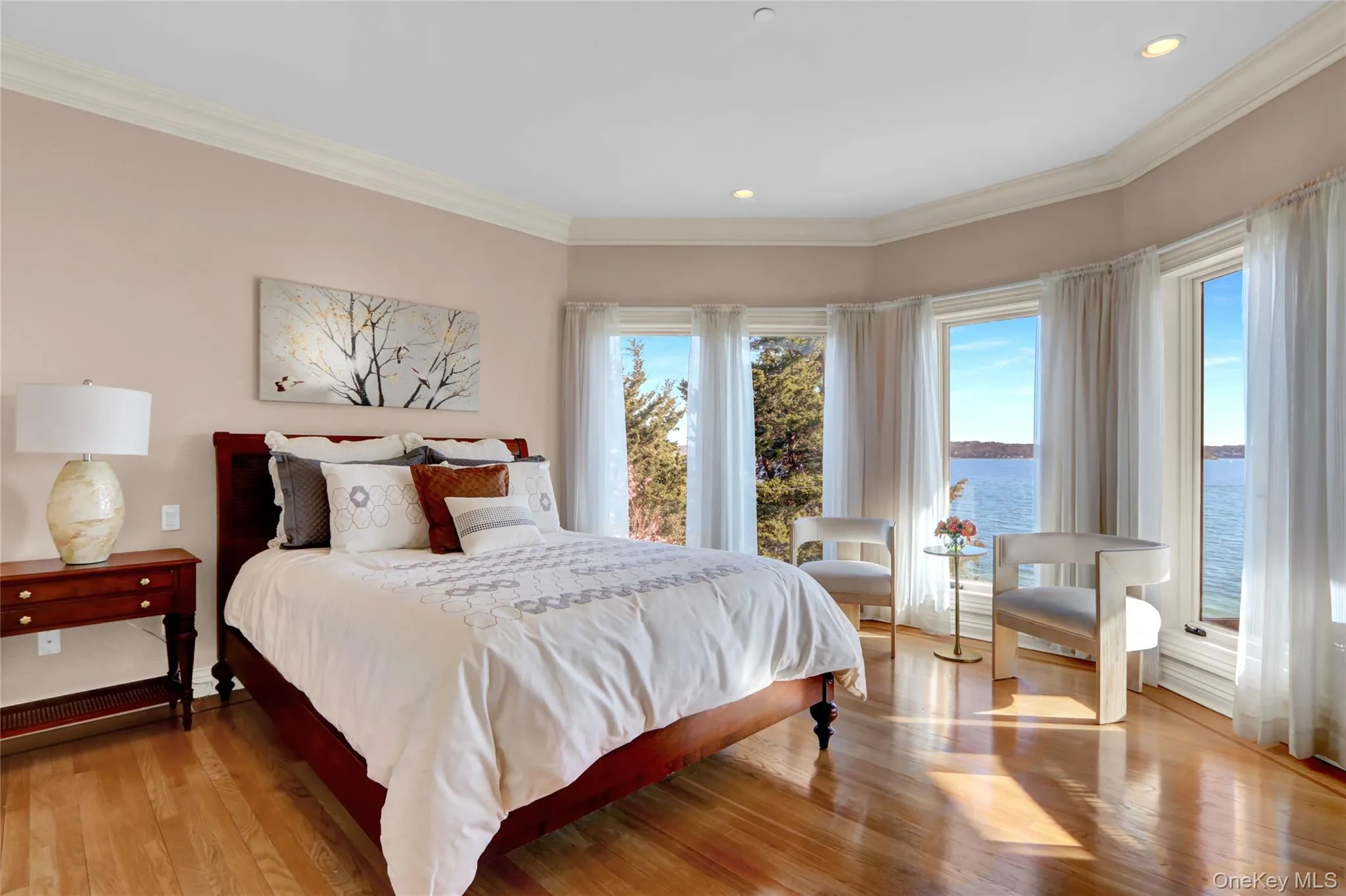 Bedroom featuring recessed lighting, wood finished floors, a water view, and crown molding Bedroom featuring recessed lighting, wood finished floors, a water view, and crown molding