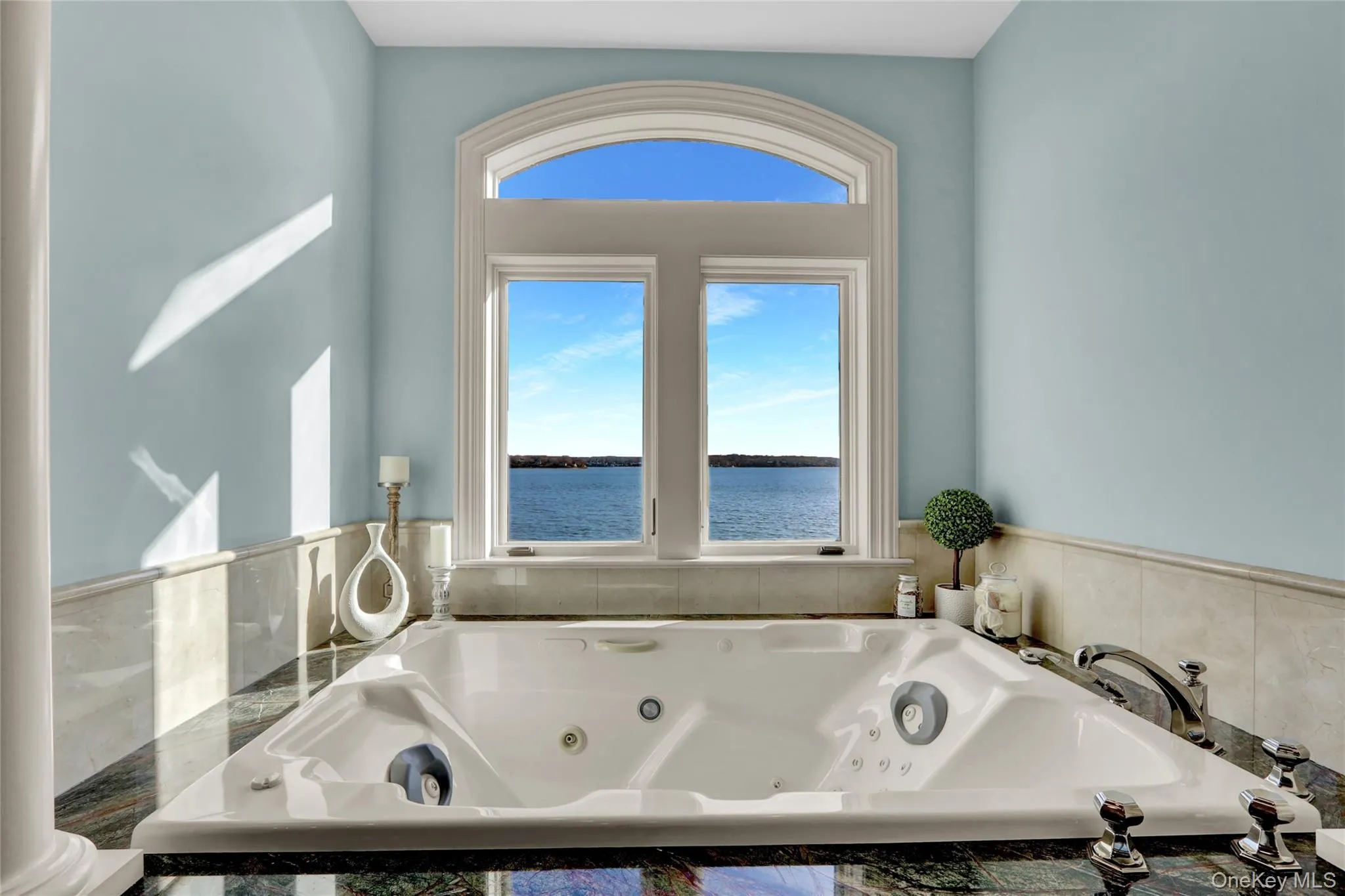 Full bath with a healthy amount of sunlight, a jetted tub, and a water view Full bath with a healthy amount of sunlight, a jetted tub, and a water view