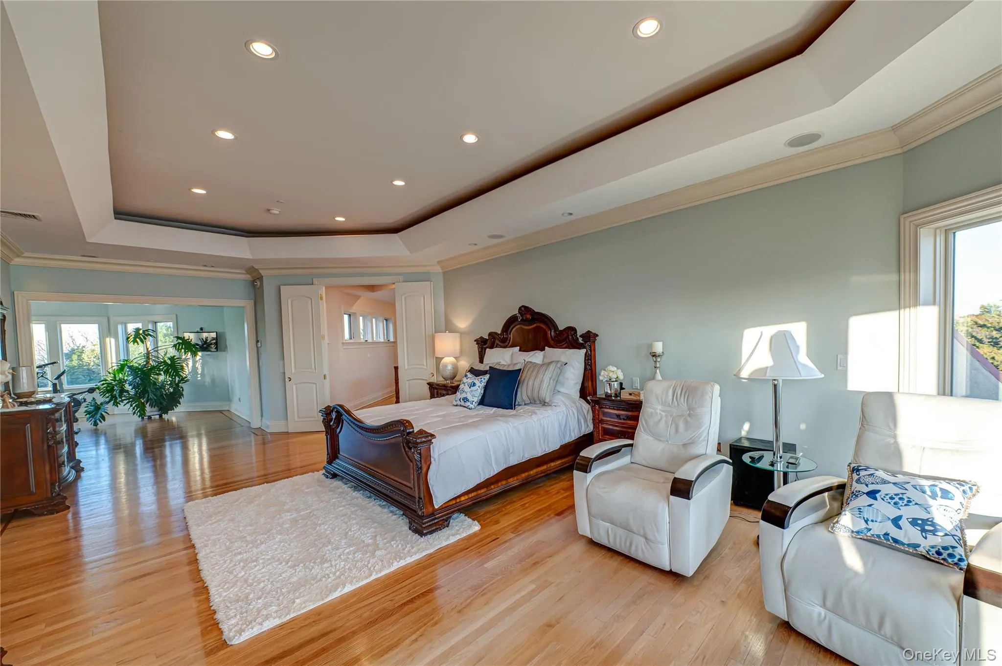 Bedroom featuring recessed lighting, a tray ceiling, and multiple windows Bedroom featuring recessed lighting, a tray ceiling, and multiple windows