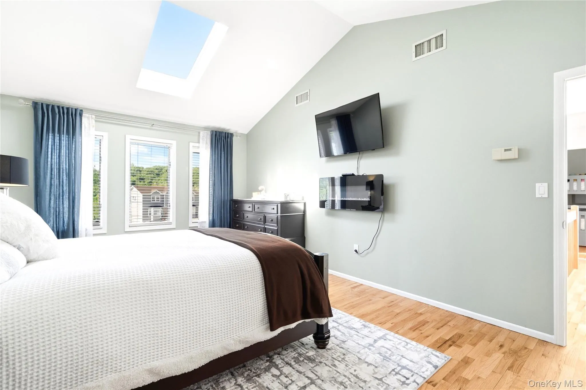 Bedroom with lofted ceiling, a skylight, and hardwood / wood-style floors Bedroom with lofted ceiling, a skylight, and hardwood / wood-style floors