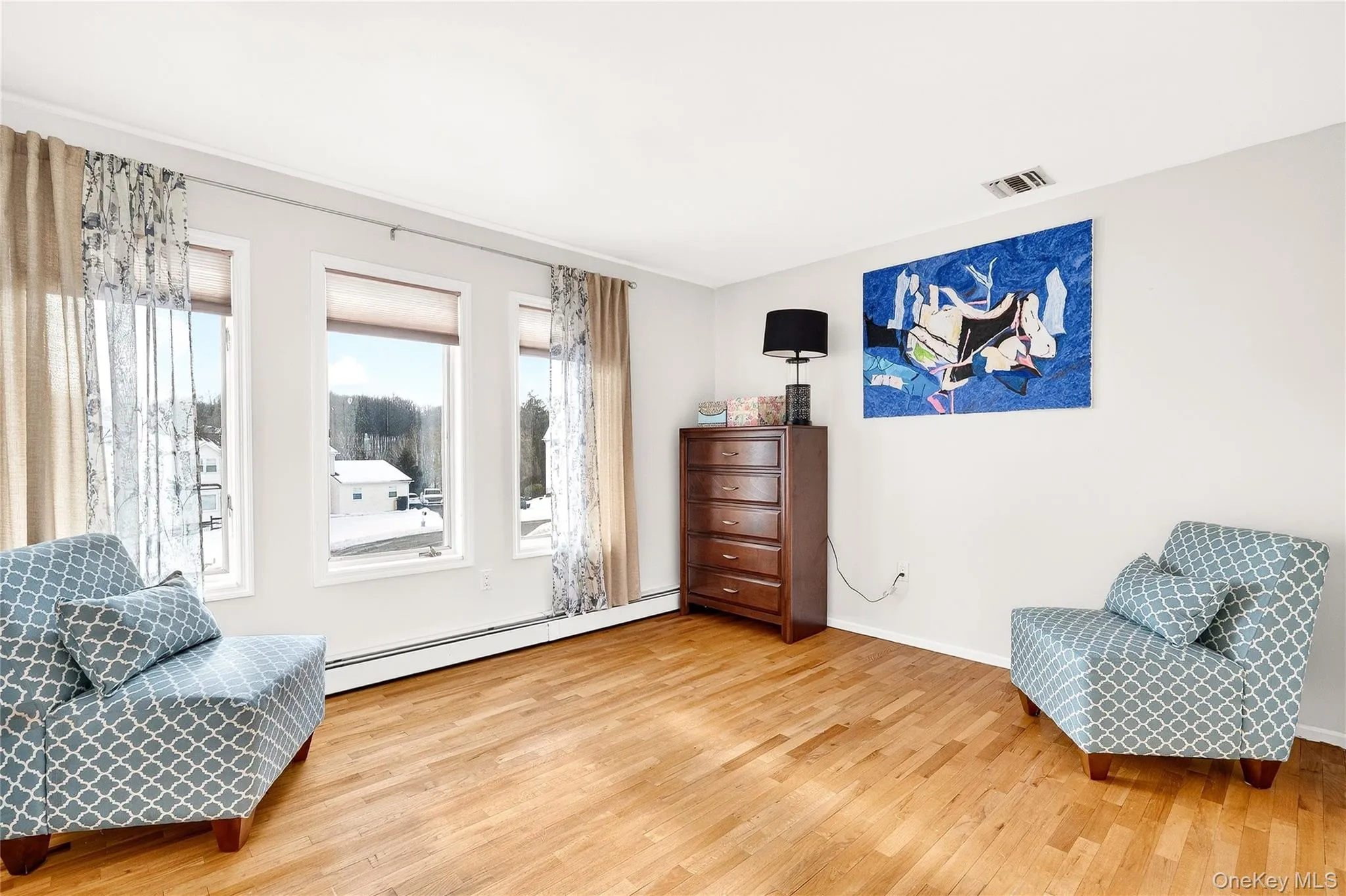 Sitting room with baseboard heating and light wood finished floors Sitting room with baseboard heating and light wood finished floors