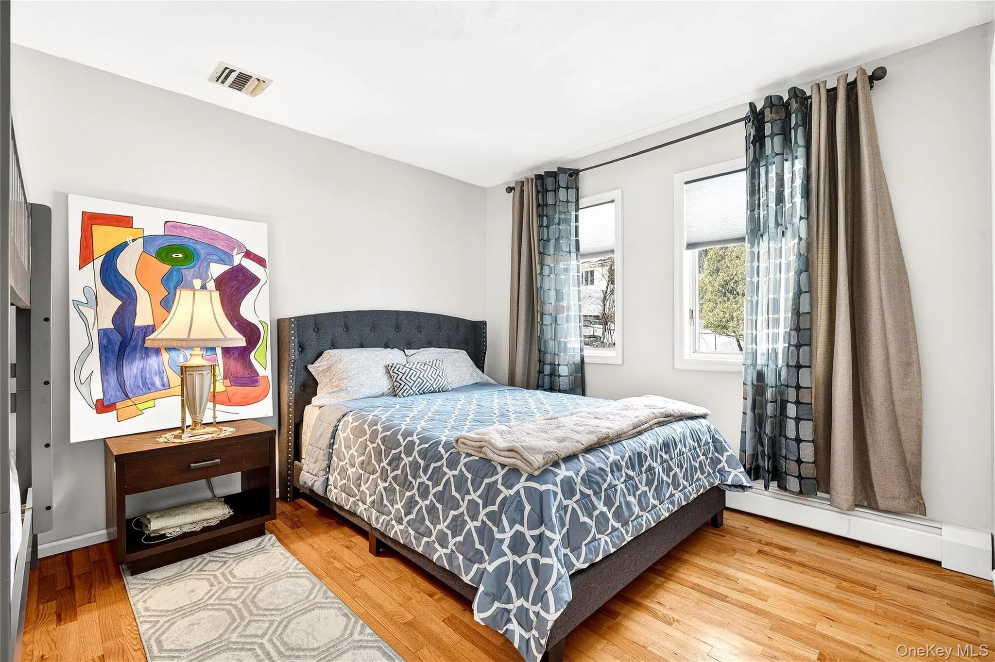 Bedroom with baseboard heating and light wood-style flooring Bedroom with baseboard heating and light wood-style flooring