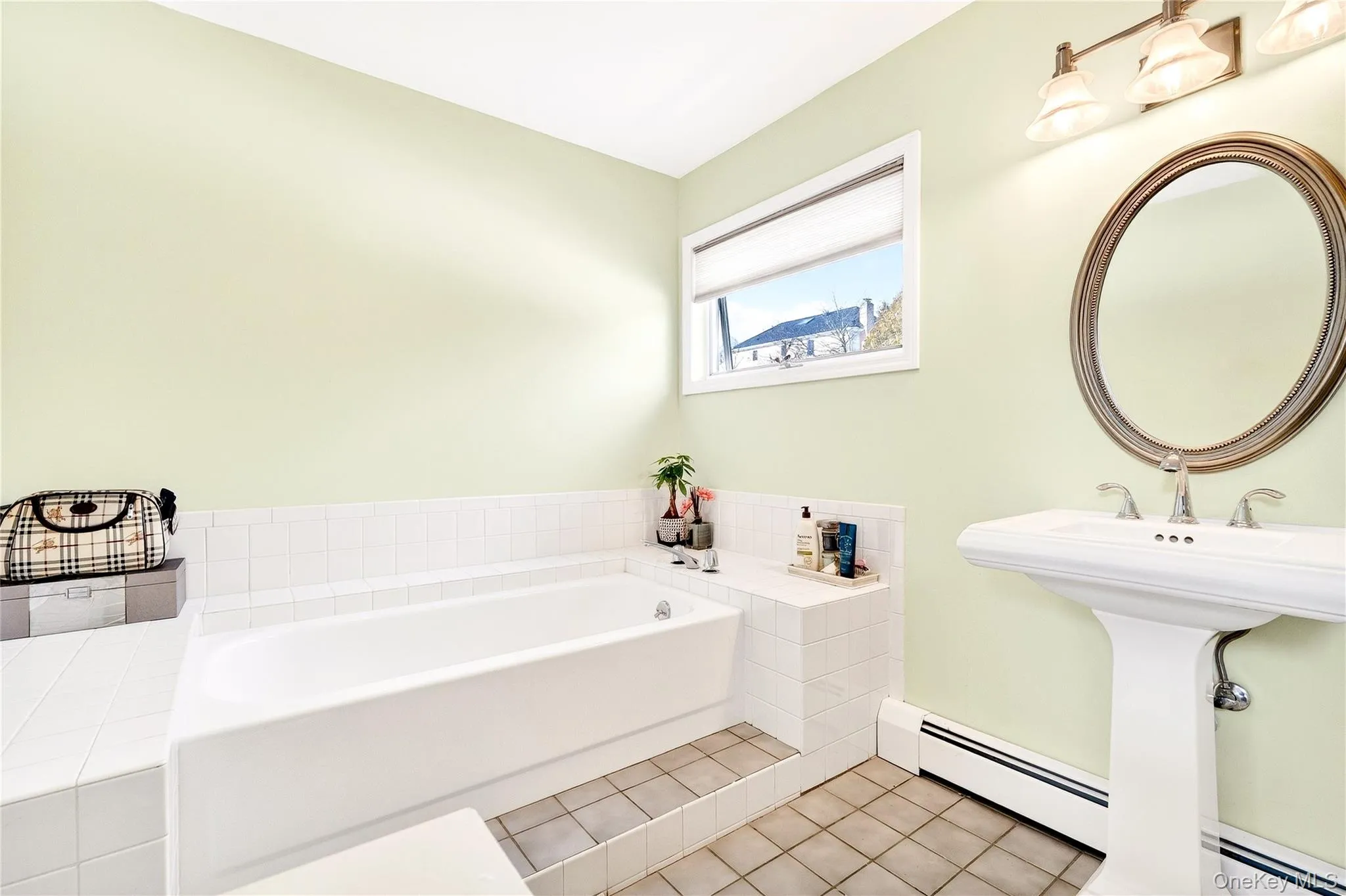 Full bathroom featuring a baseboard radiator, a garden tub, and light tile patterned flooring Full bathroom featuring a baseboard radiator, a garden tub, and light tile patterned flooring