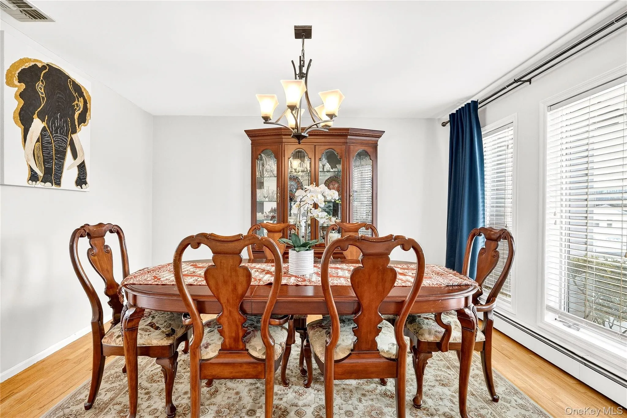 with a baseboard radiator, a chandelier, and light wood-type flooring with a baseboard radiator, a chandelier, and light wood-type flooring