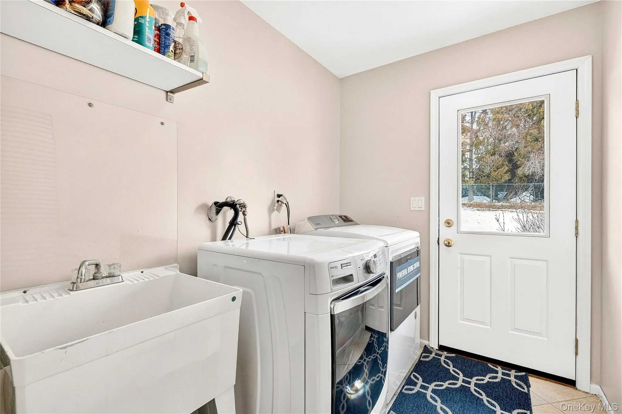 Washroom featuring washer and clothes dryer and tile patterned floors Washroom featuring washer and clothes dryer and tile patterned floors