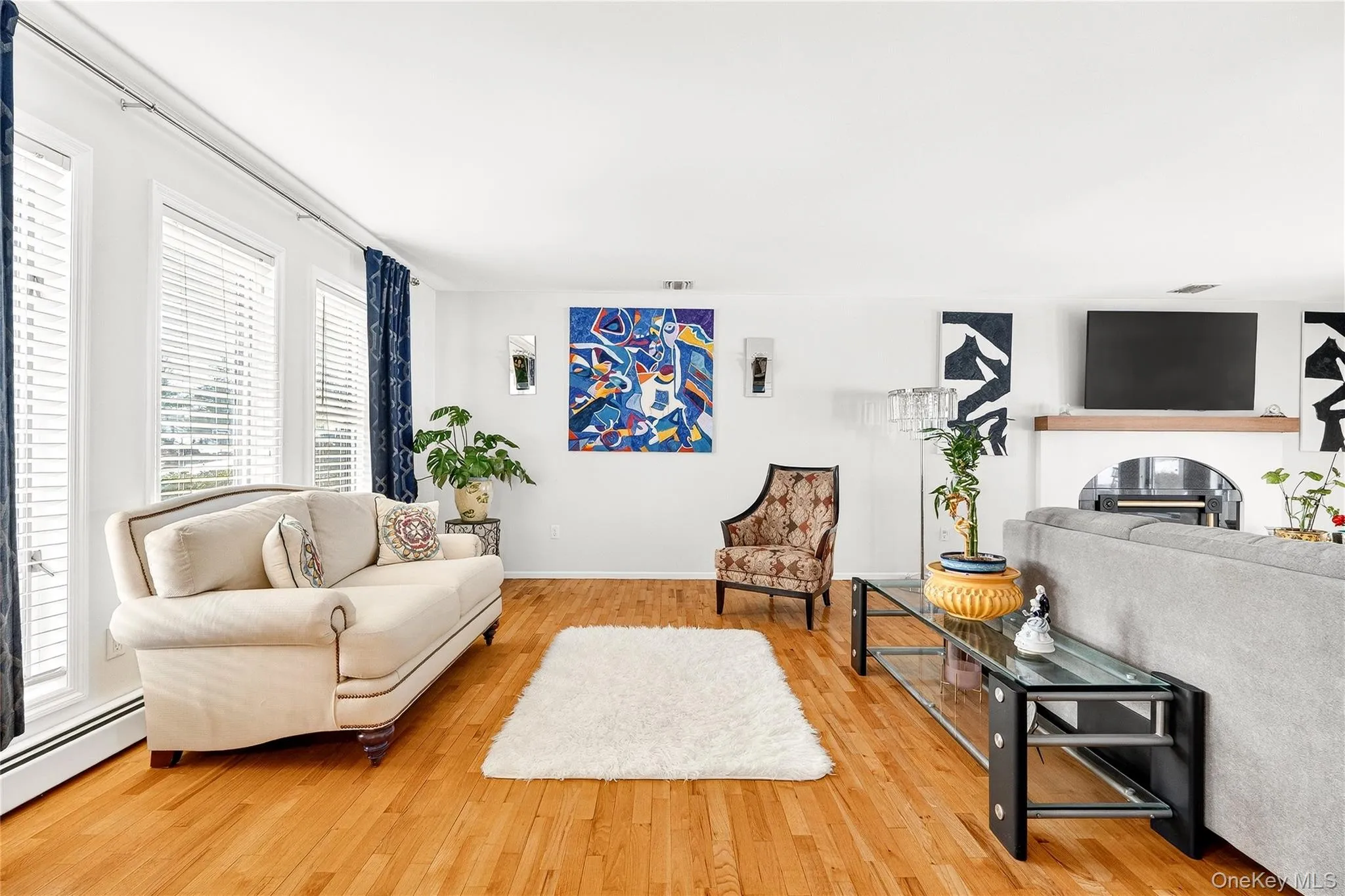 with light wood-type flooring and a glass covered fireplace with light wood-type flooring and a glass covered fireplace