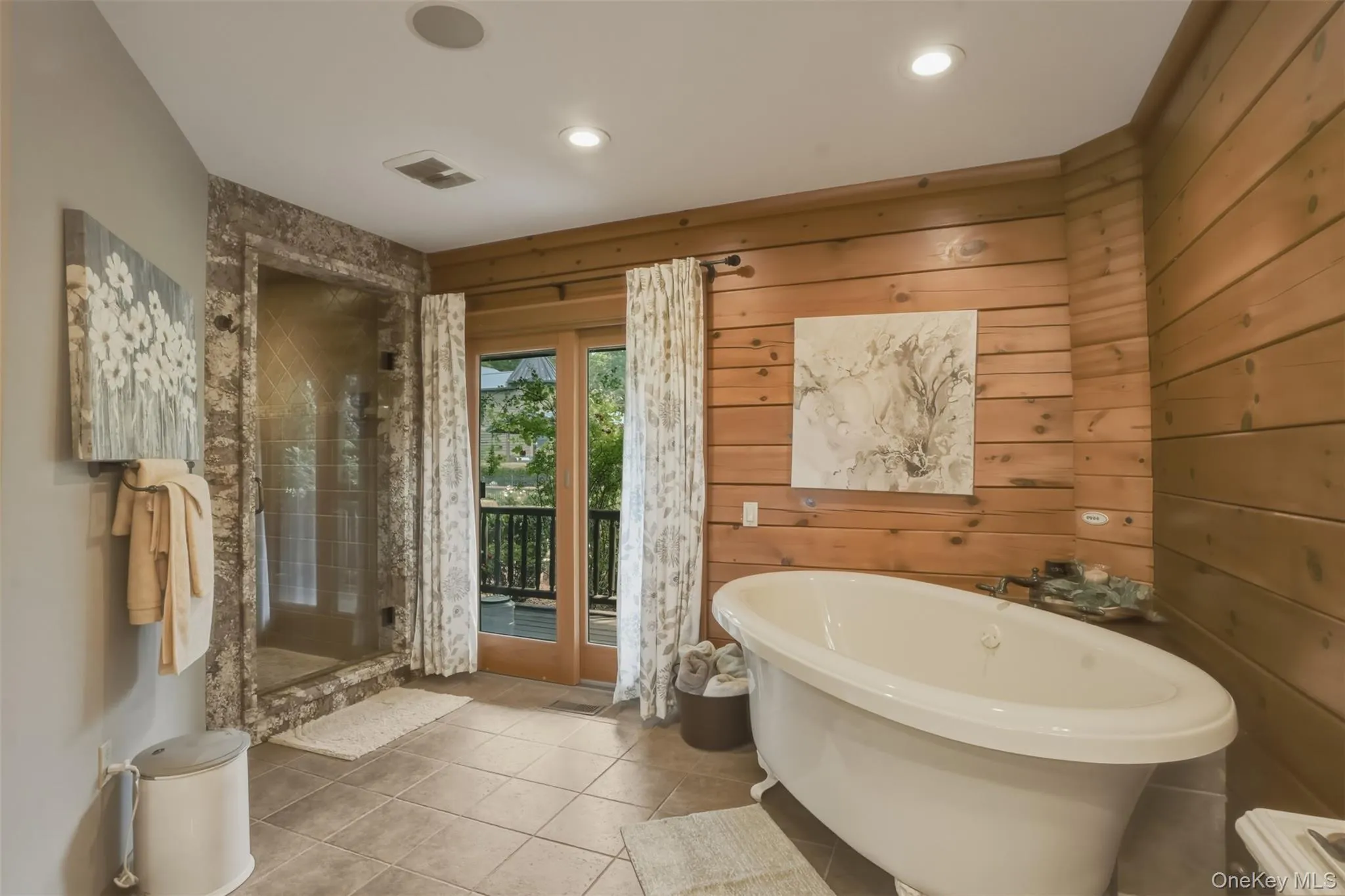 luxurious primary suite complete with a walk-in closet and spa-inspired ensuite featuring a floating jetted soaking tub, oversized tiled shower, and double vanity. Nearly every room opens directly to inviting outdoor living spaces that seamlessly connect the home to its natural surroundings. luxurious primary suite complete with a walk-in closet and spa-inspired ensuite featuring a floating jetted soaking tub, oversized tiled shower, and double vanity. Nearly every room opens directly to inviting outdoor living spaces that seamlessly connect the home to its natural surroundings.