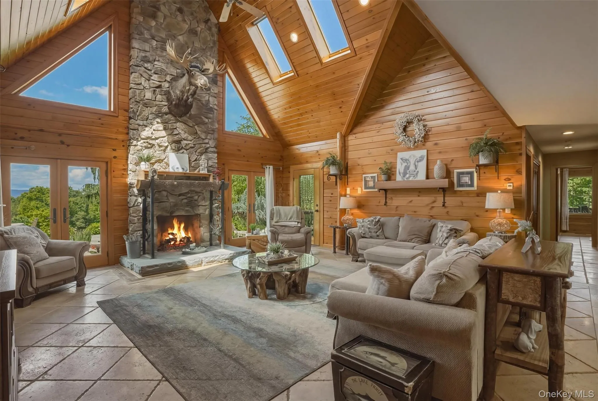 The dramatic great room serves as the heart of the home with floor-to-ceiling windows and a striking stone fireplace. The dramatic great room serves as the heart of the home with floor-to-ceiling windows and a striking stone fireplace.