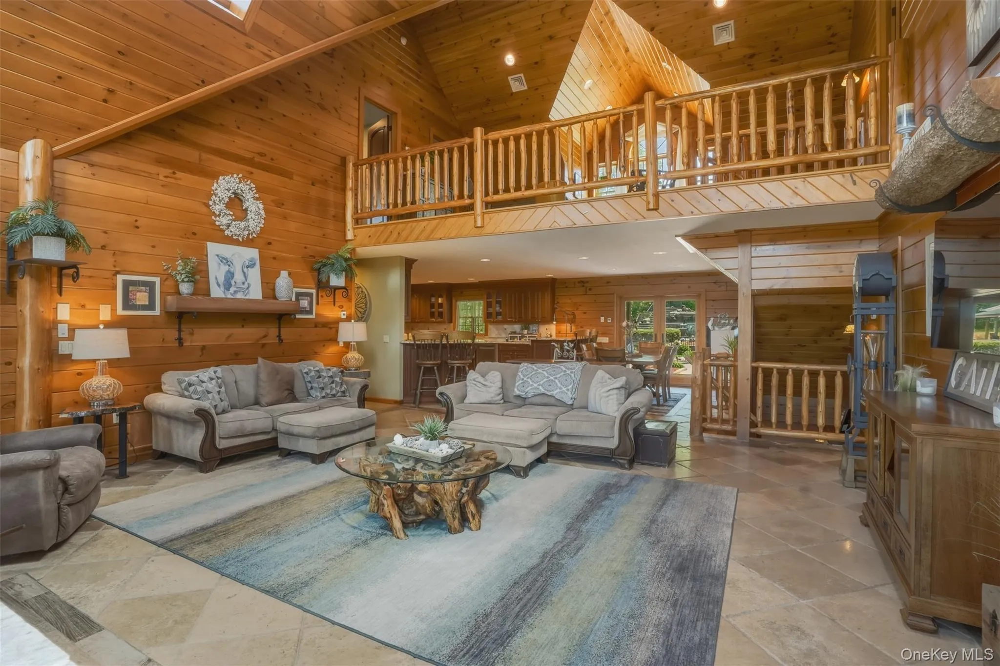 The dramatic great room serves as the heart of the home with floor-to-ceiling windows and a striking stone fireplace. The dramatic great room serves as the heart of the home with floor-to-ceiling windows and a striking stone fireplace.