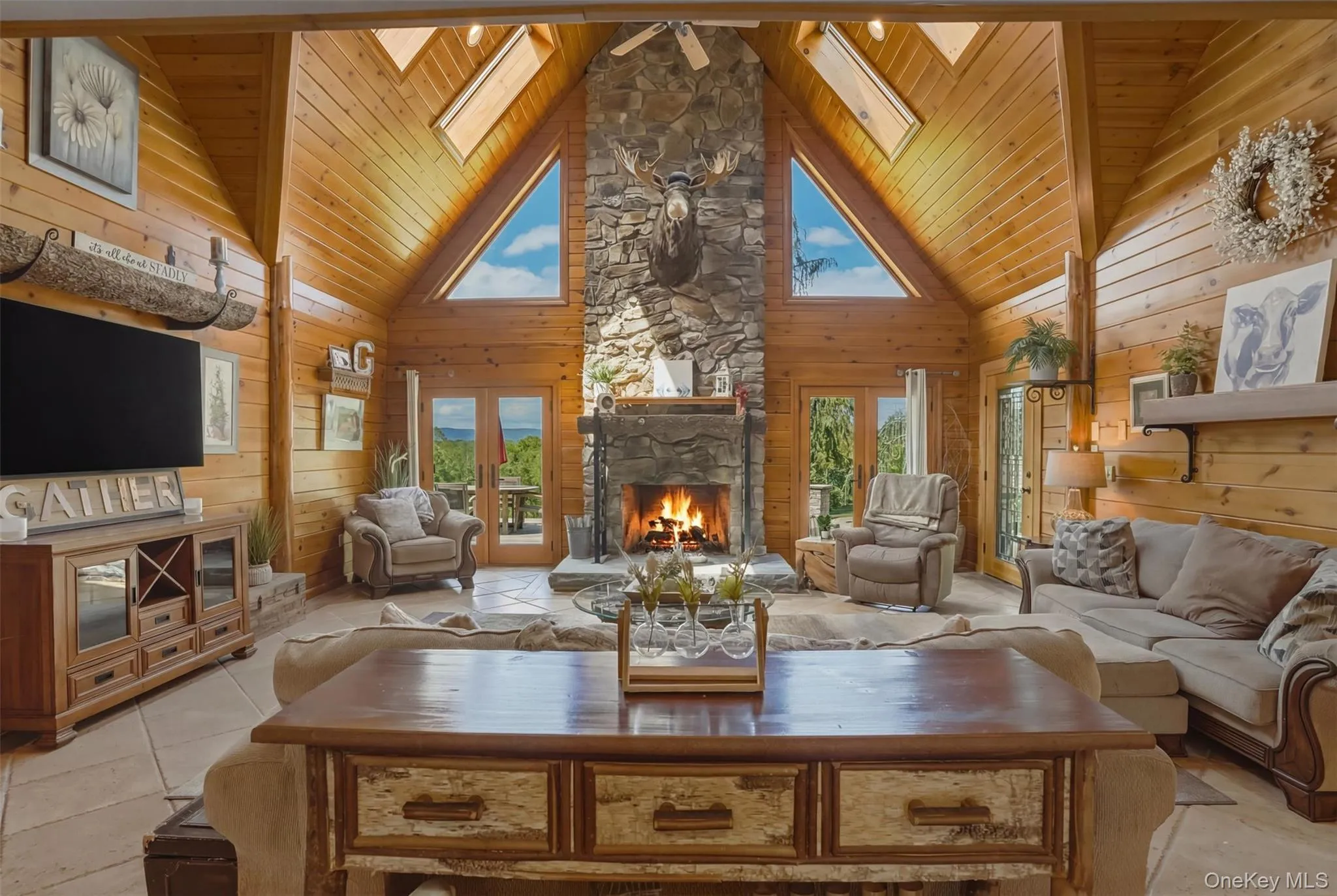 The dramatic great room serves as the heart of the home with floor-to-ceiling windows and a striking stone fireplace. The dramatic great room serves as the heart of the home with floor-to-ceiling windows and a striking stone fireplace.