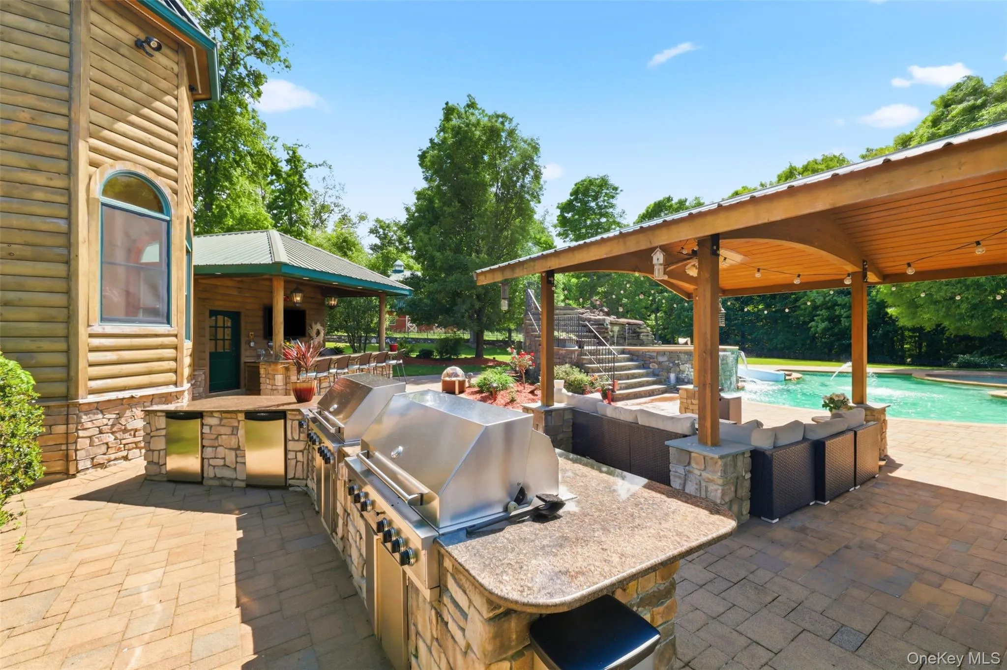 Step outside and discover a true resort-style oasis. The spectacular multi-level heated pool features a slide, wading area, and extensive lounging spaces. The pool house includes a tiki bar, full bathroom, and outdoor shower, while dual Thor grills, granite serving stations, and a shaded pergola create the ultimate setting for unforgettable gatherings. Step outside and discover a true resort-style oasis. The spectacular multi-level heated pool features a slide, wading area, and extensive lounging spaces. The pool house includes a tiki bar, full bathroom, and outdoor shower, while dual Thor grills, granite serving stations, and a shaded pergola create the ultimate setting for unforgettable gatherings.