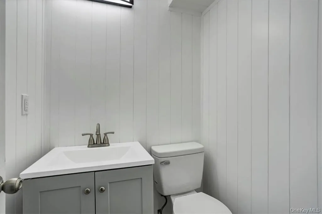 Half bathroom featuring vanity and toilet Half bathroom featuring vanity and toilet