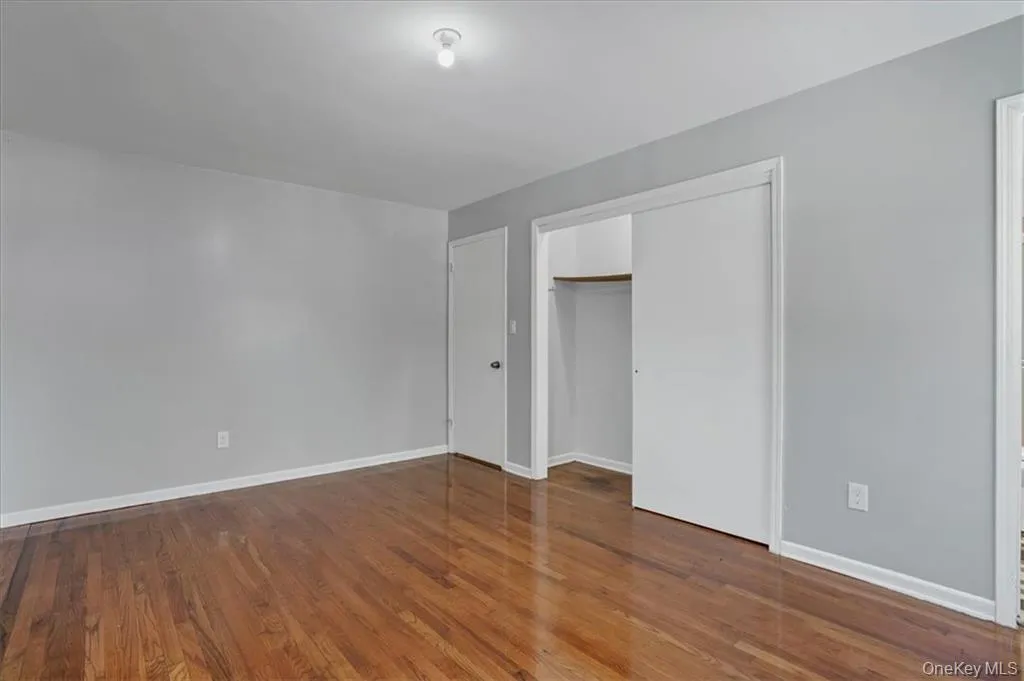Unfurnished bedroom with dark wood-type flooring and a closet Unfurnished bedroom with dark wood-type flooring and a closet