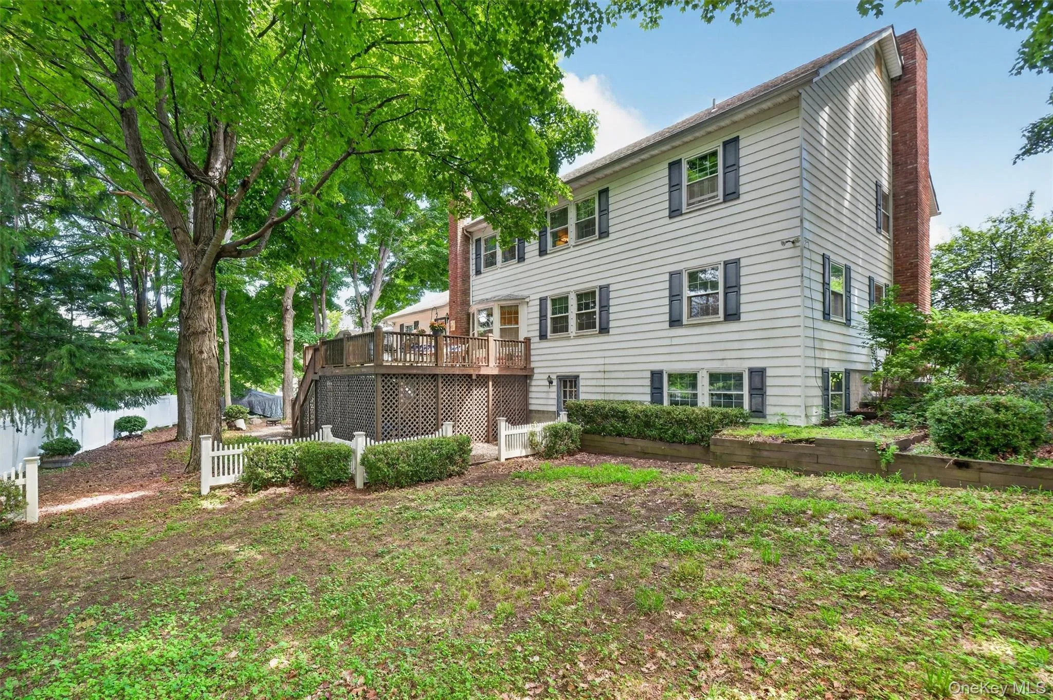 Rear elevation shows lawns, lower level entry and expansive back deck for entertaining. Rear elevation shows lawns, lower level entry and expansive back deck for entertaining.