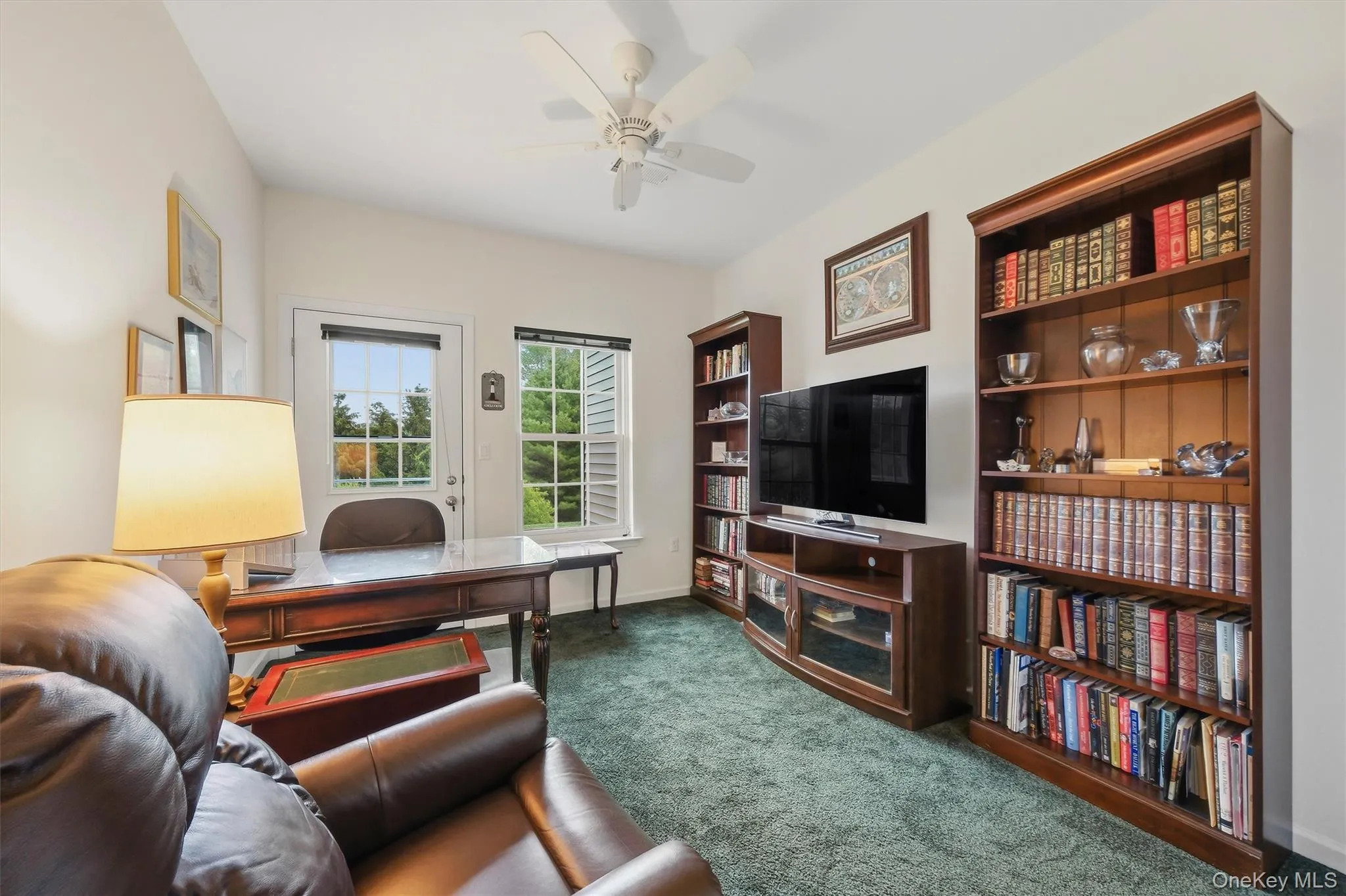 Secondary bedroom featuring wall-to-wall carpeting, ceiling fan, and an entrance to a private rear patio surrounded by natural surroundings. Secondary bedroom featuring wall-to-wall carpeting, ceiling fan, and an entrance to a private rear patio surrounded by natural surroundings.