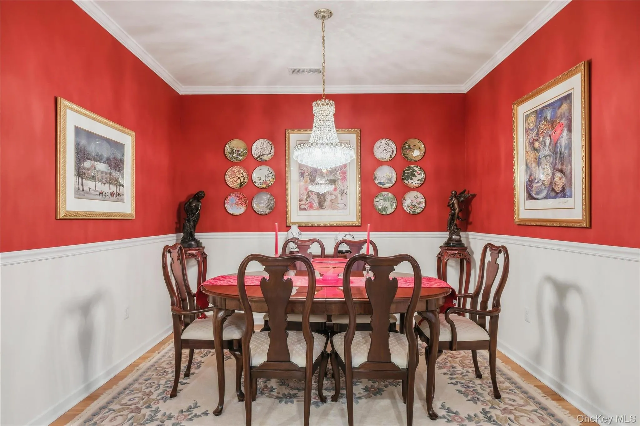 Formal dining room with hardwood floors, crown molding, wainscoting, and an open-concept layout adjacent to the kitchen. Formal dining room with hardwood floors, crown molding, wainscoting, and an open-concept layout adjacent to the kitchen.