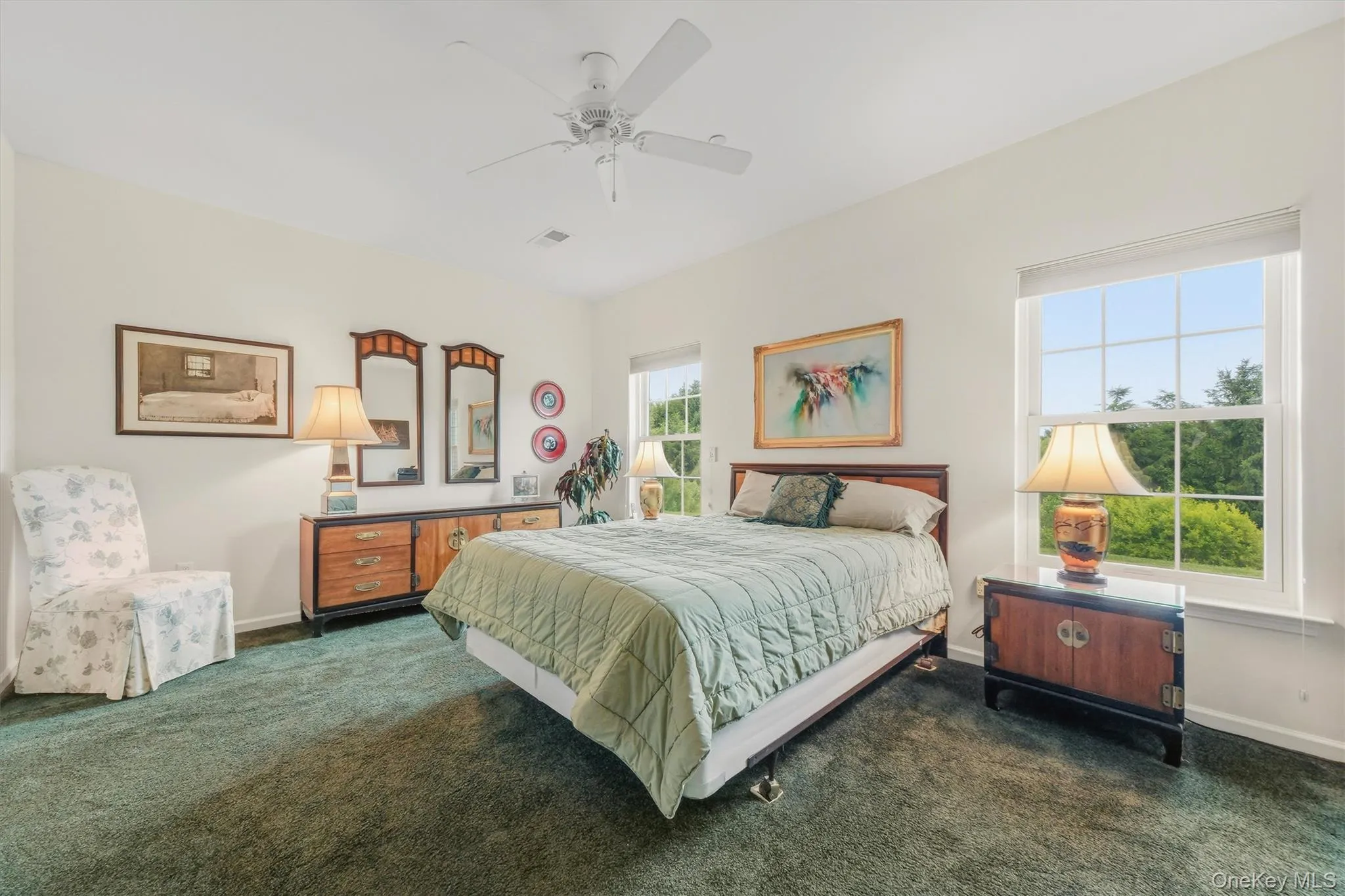 Primary bedroom featuring wall-to-wall carpeting, ensuite bathroom, walk-in closet, additional closet, and peaceful views of the backyard. Primary bedroom featuring wall-to-wall carpeting, ensuite bathroom, walk-in closet, additional closet, and peaceful views of the backyard.