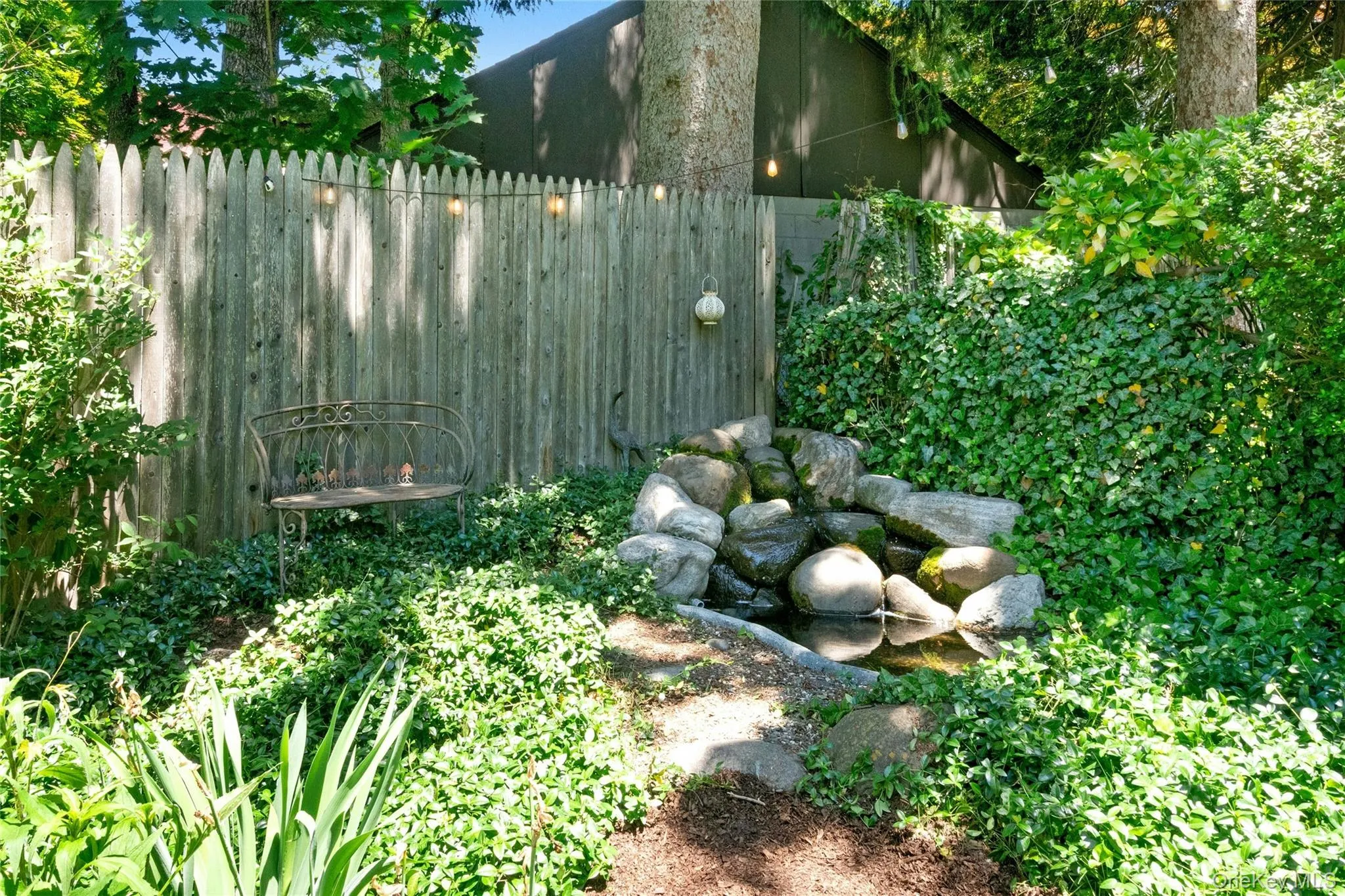 A waterfall adds to the appeal of this level back yard with just the right mixture of sun and shade. A waterfall adds to the appeal of this level back yard with just the right mixture of sun and shade.