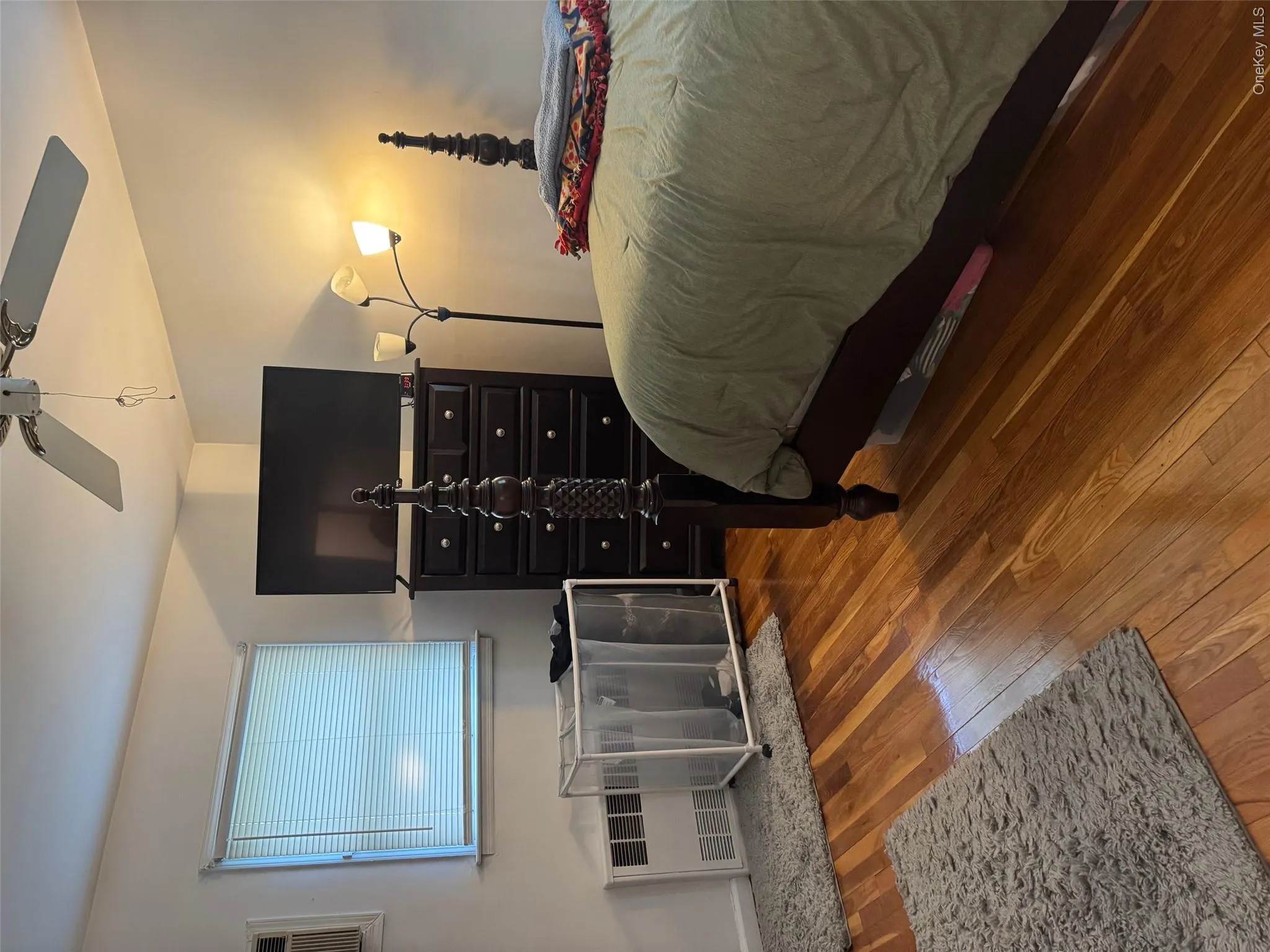 Bedroom with hardwood / wood-style flooring, a ceiling fan, and a wall unit AC Bedroom with hardwood / wood-style flooring, a ceiling fan, and a wall unit AC