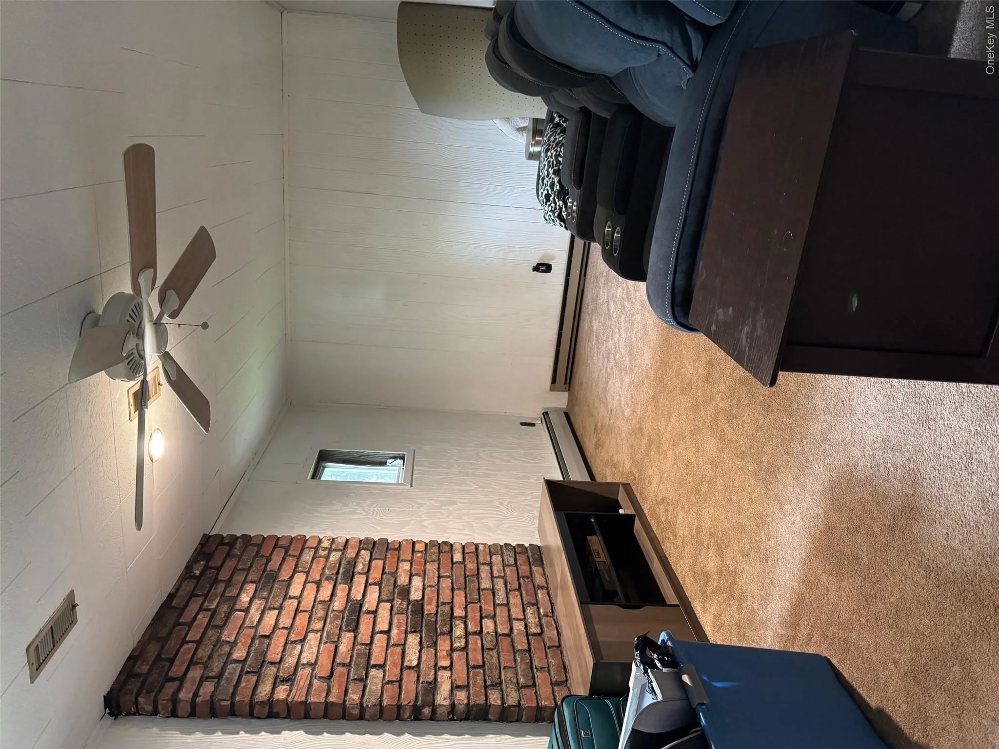 Living room featuring a baseboard heating unit, carpet floors, ceiling fan, and a baseboard radiator Living room featuring a baseboard heating unit, carpet floors, ceiling fan, and a baseboard radiator