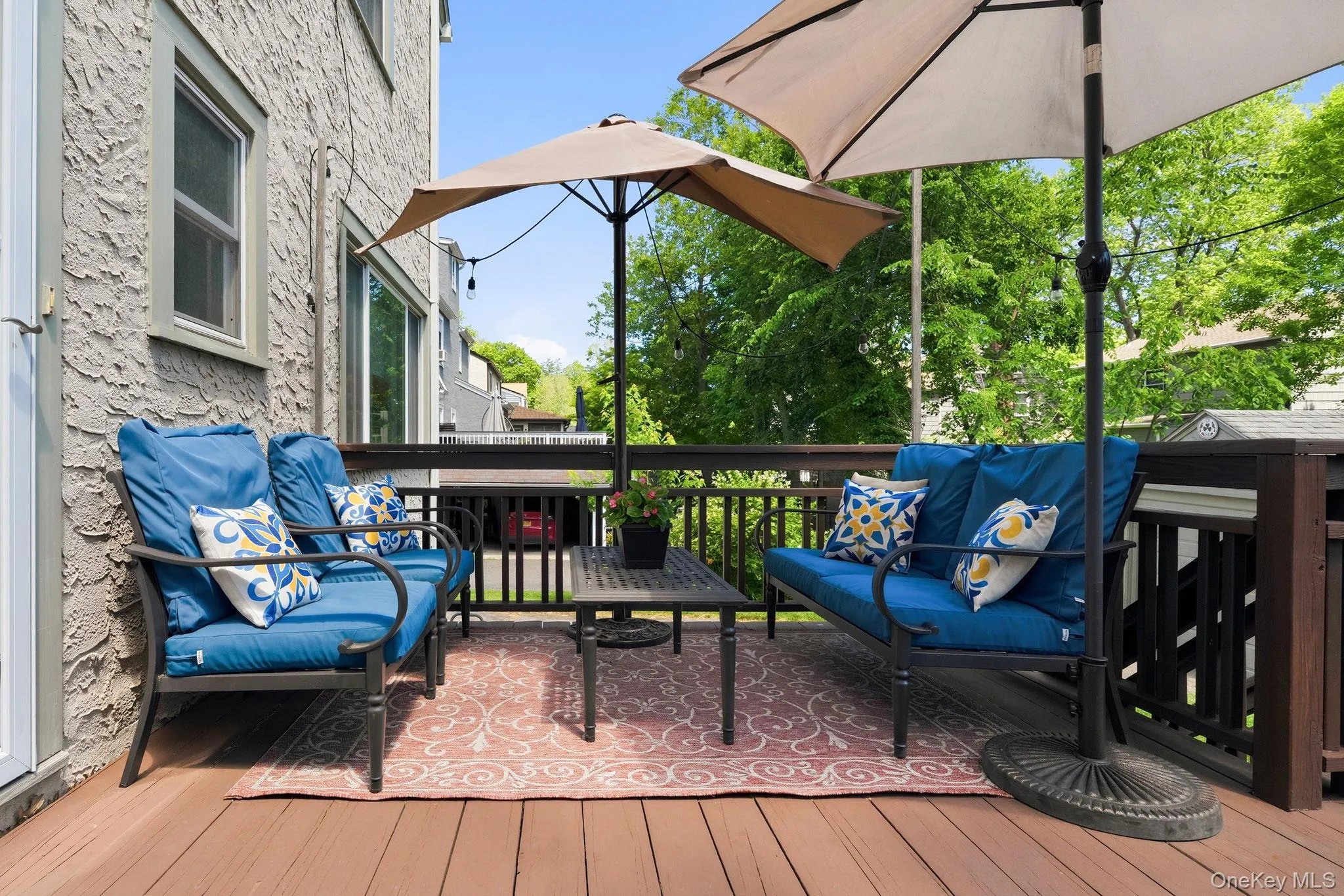 A seamless indoor-outdoor connection leads to a spacious wooden deck with patio seating and BBQ setup, perfect for gatherings and summer living. A seamless indoor-outdoor connection leads to a spacious wooden deck with patio seating and BBQ setup, perfect for gatherings and summer living.