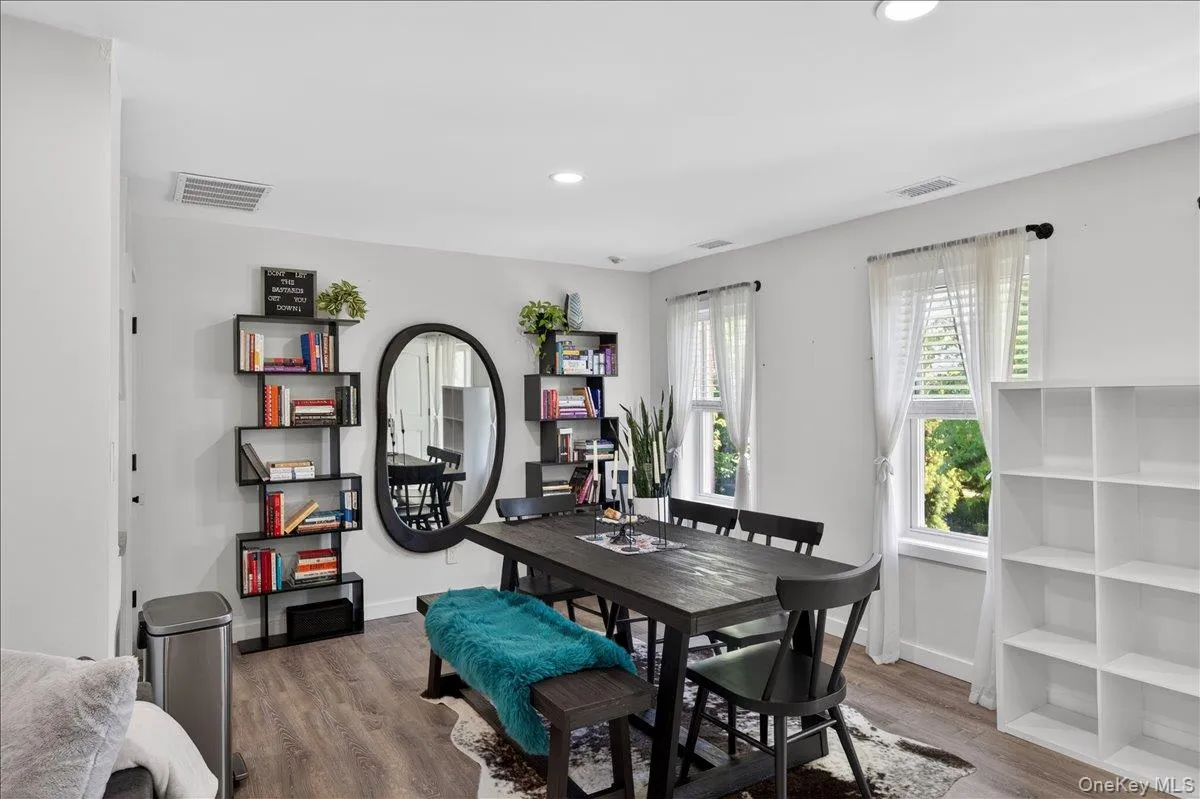 Spacious room featuring wood-finish flooring, recessed lighting, and multiple windows Spacious room featuring wood-finish flooring, recessed lighting, and multiple windows
