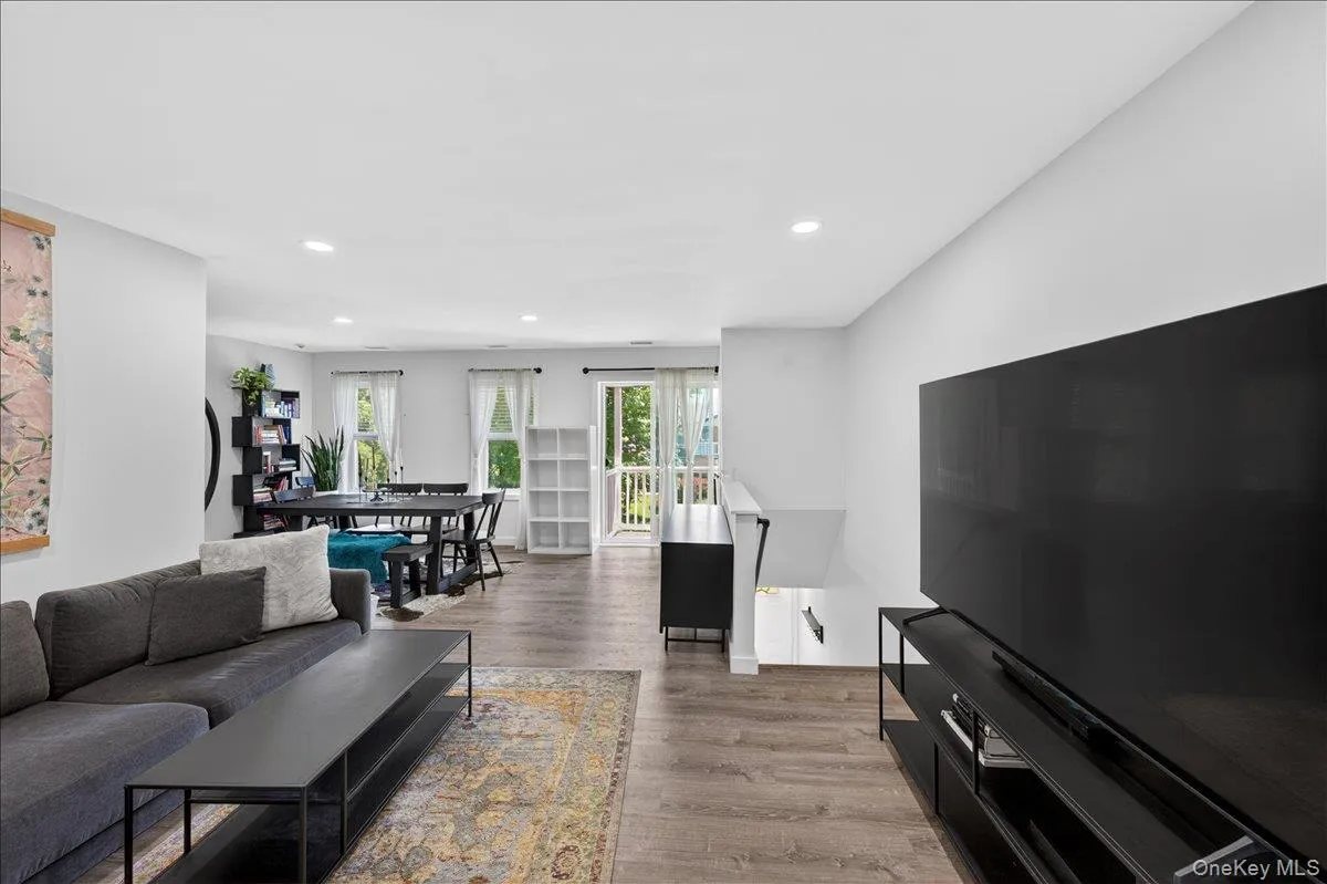 Open-concept living space featuring wood-finish flooring and recessed lighting Open-concept living space featuring wood-finish flooring and recessed lighting