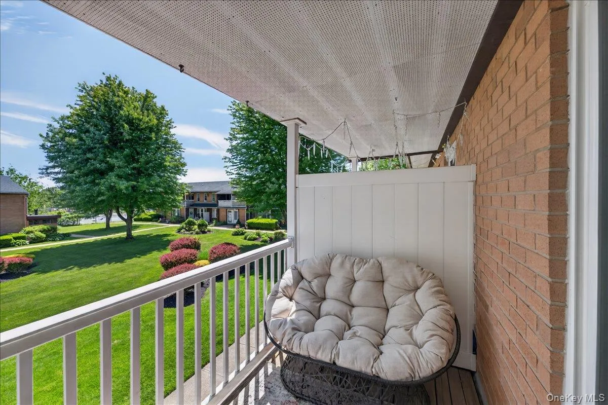 Covered balcony with white railing and brick exterior Covered balcony with white railing and brick exterior