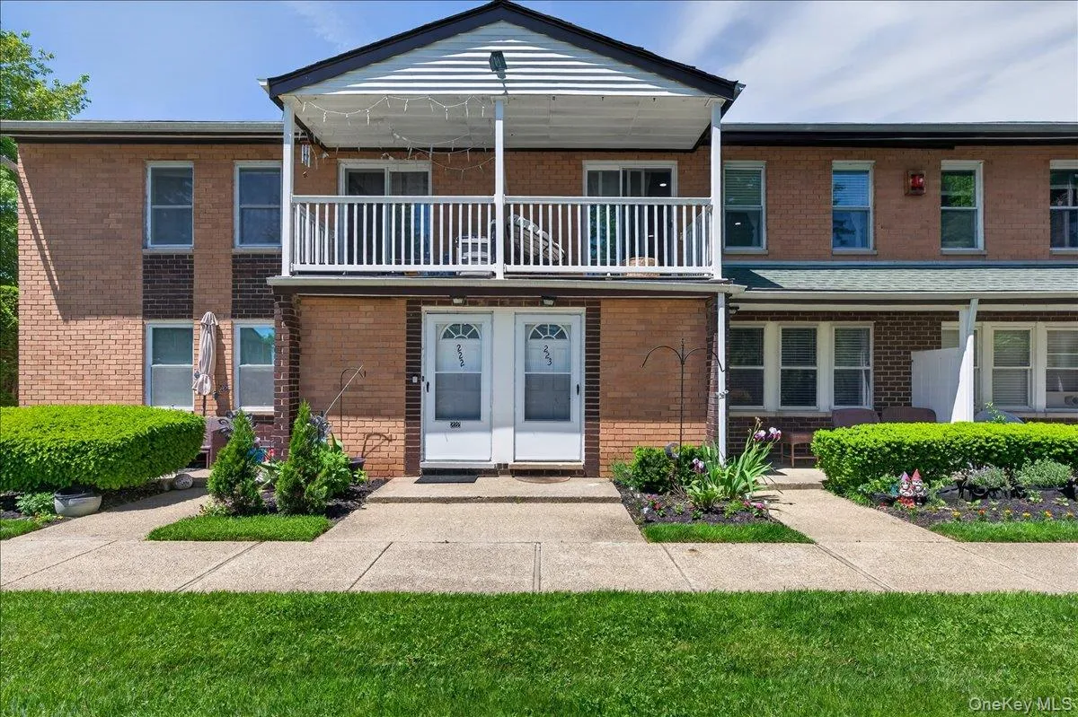 Brick facade with white trim and a second-story balcony Brick facade with white trim and a second-story balcony