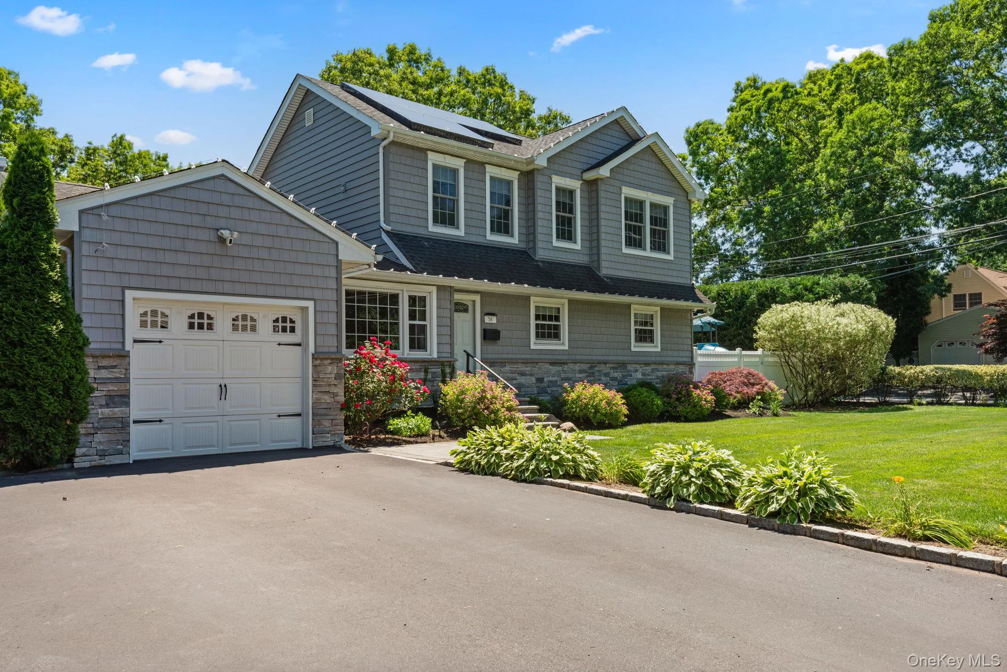 Exterior featuring grey siding and stone veneer accents Exterior featuring grey siding and stone veneer accents