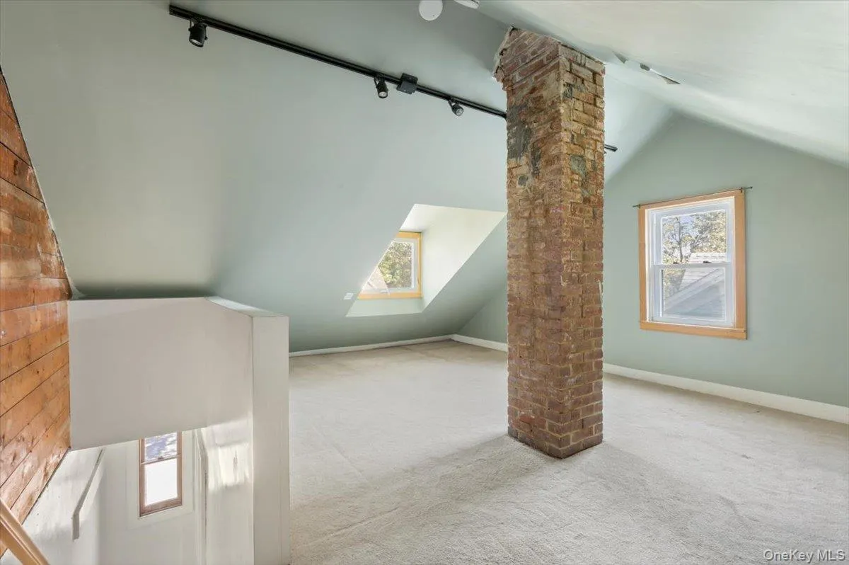 Bonus room with decorative columns, carpet flooring, vaulted ceiling, and a healthy amount of sunlight Bonus room with decorative columns, carpet flooring, vaulted ceiling, and a healthy amount of sunlight