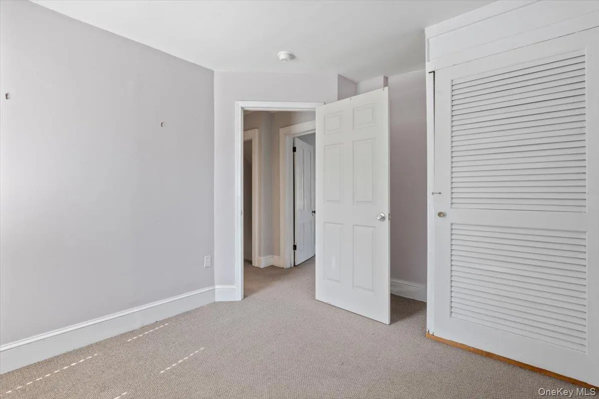 Unfurnished bedroom with a closet, carpet flooring, and baseboards Unfurnished bedroom with a closet, carpet flooring, and baseboards