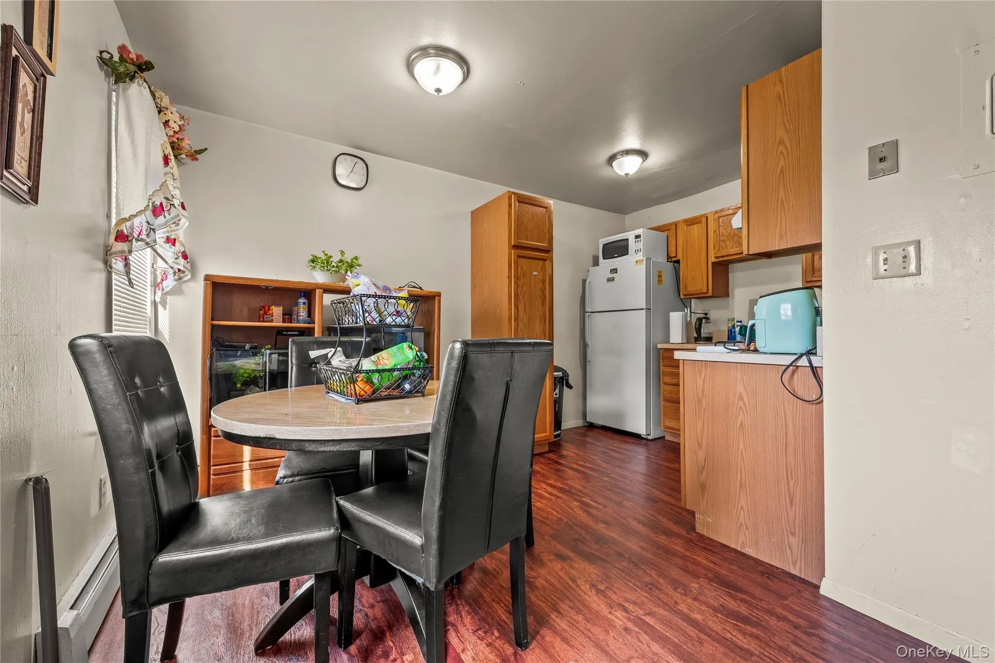 Dining space with dark wood finished floors and baseboard heating Dining space with dark wood finished floors and baseboard heating