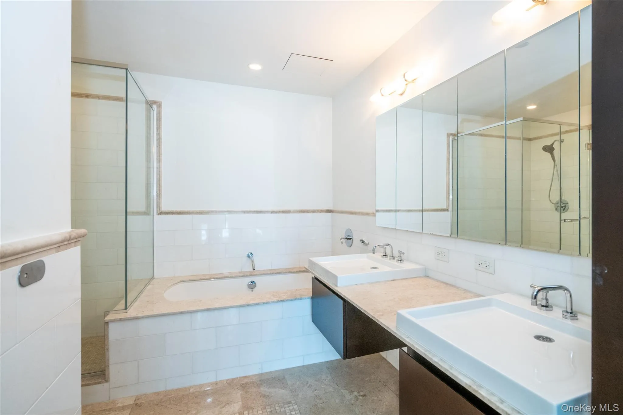 Bathroom with a garden tub, double vanity, tiled shower, and tile walls Bathroom with a garden tub, double vanity, tiled shower, and tile walls