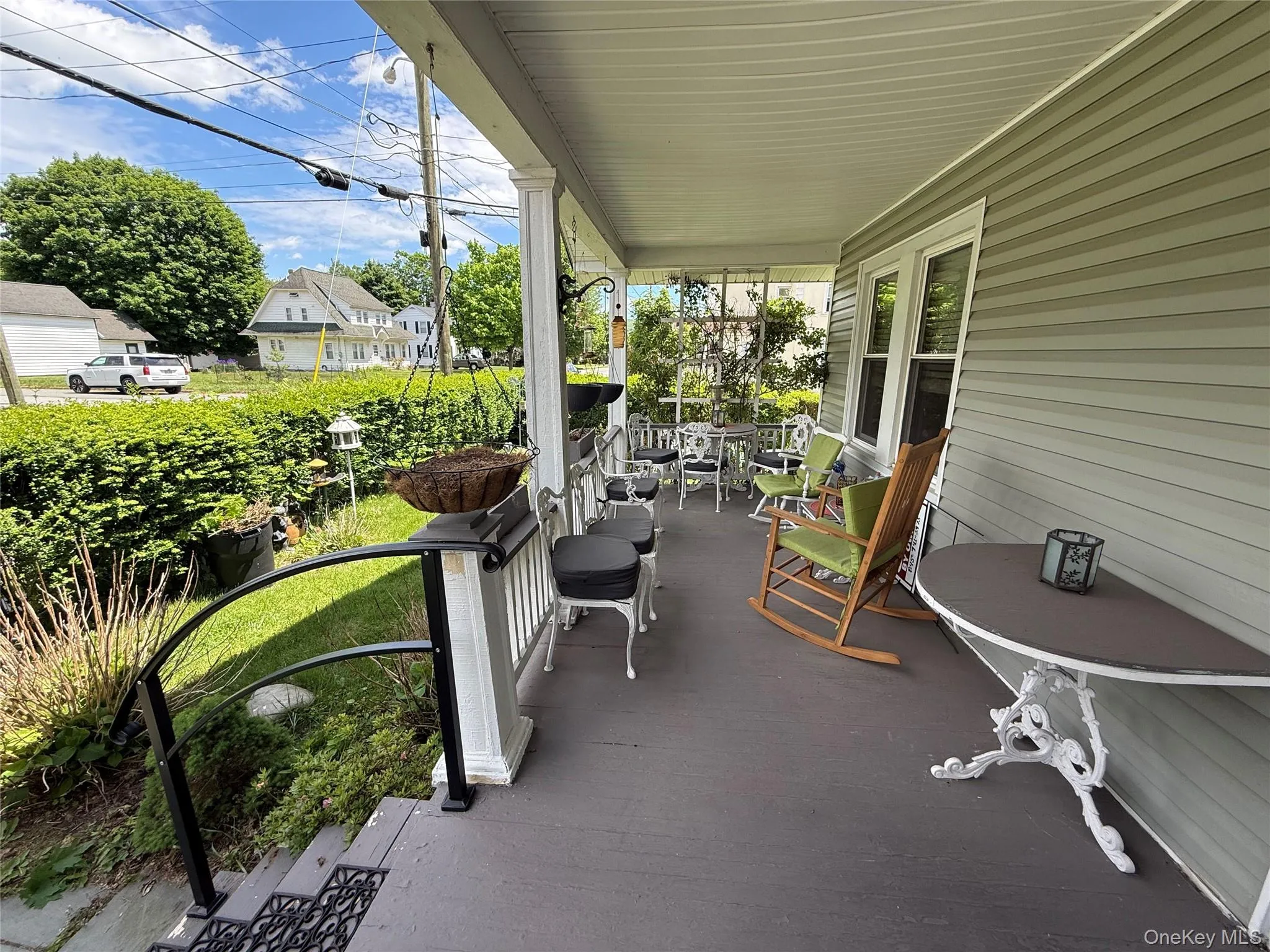 Charming front exterior featuring covered porch, mature landscaping, and inviting curb appeal Charming front exterior featuring covered porch, mature landscaping, and inviting curb appeal