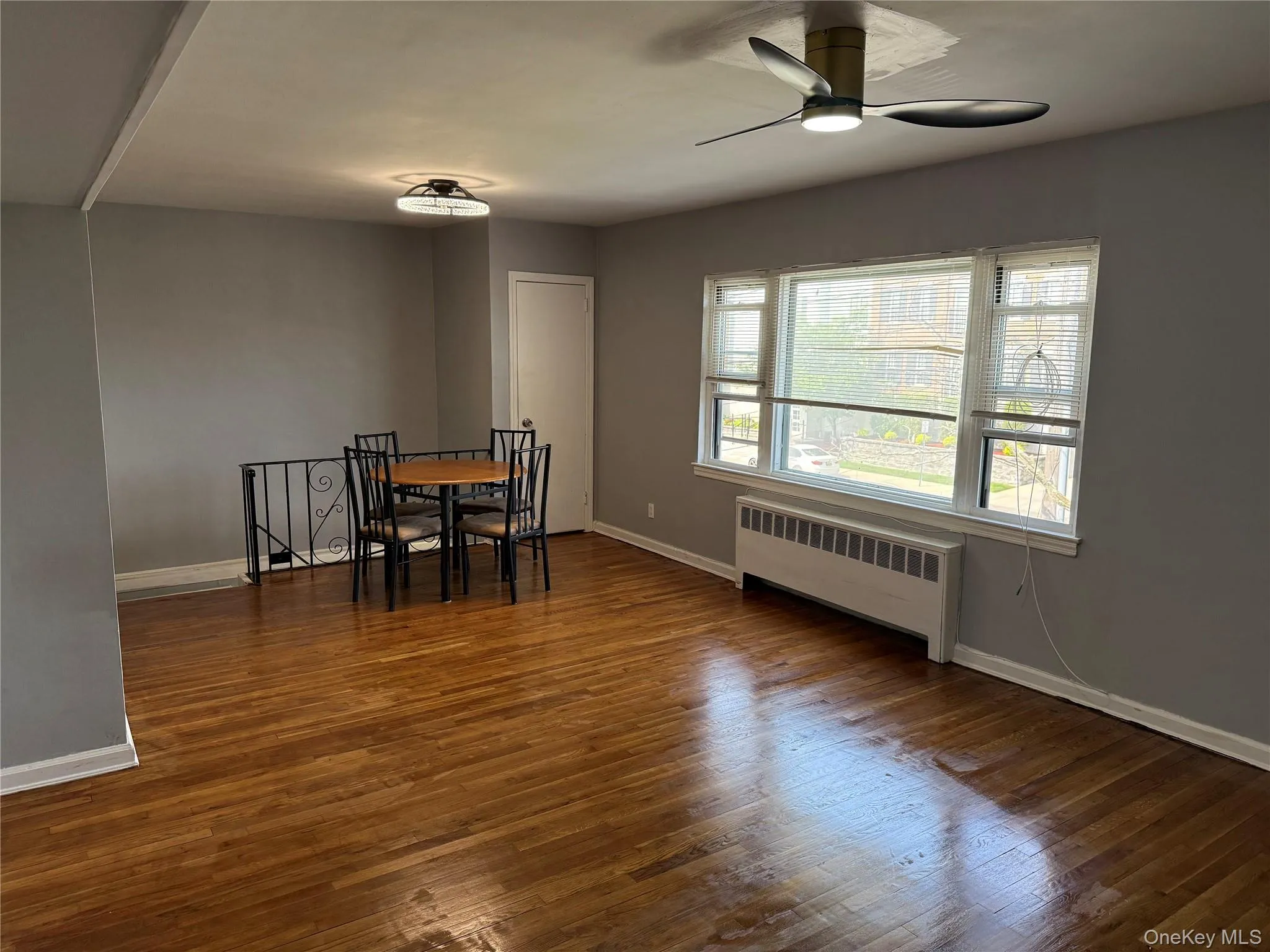 Dining space featuring radiator, wood finished floors, and ceiling fan Dining space featuring radiator, wood finished floors, and ceiling fan