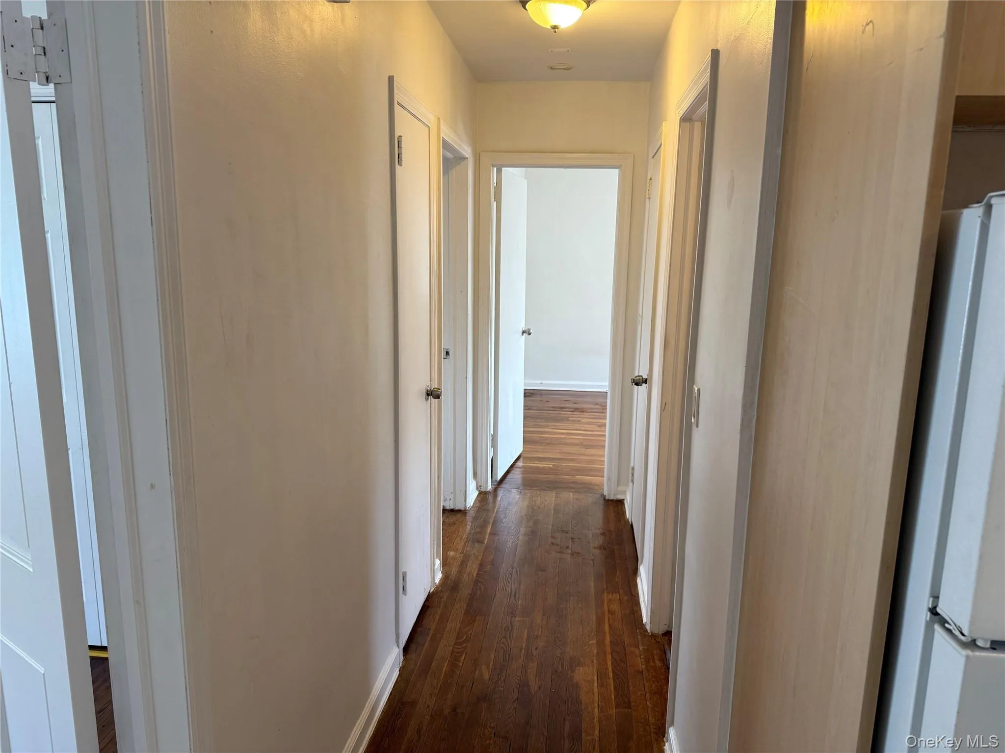 Corridor with dark wood finished floors and baseboards Corridor with dark wood finished floors and baseboards