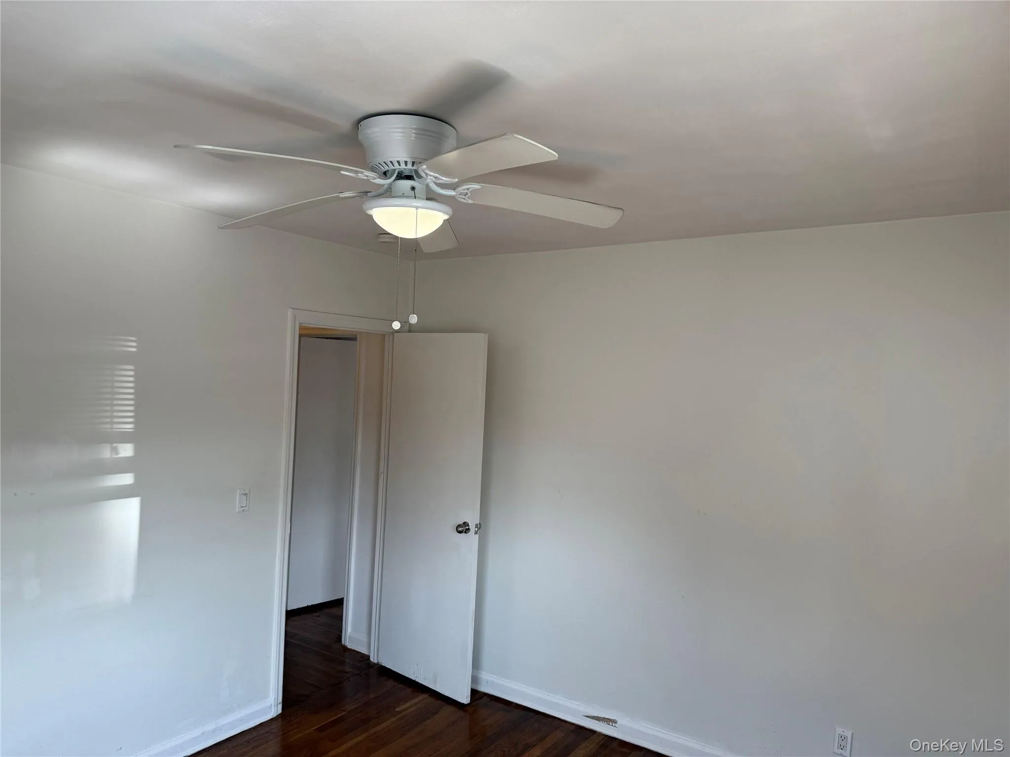 Spare room featuring ceiling fan and dark wood finished floors Spare room featuring ceiling fan and dark wood finished floors